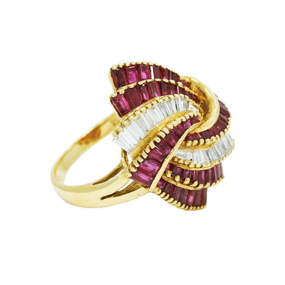 Up for sale is this 18k yellow gold ruby and diamond baguette swirl ring. It has twenty two (22) diamonds weighing approximatley .50 carats total weight and forty six (46) rubies weighing approxomatley 1.00 carats total weight. It measures 1.25 inch