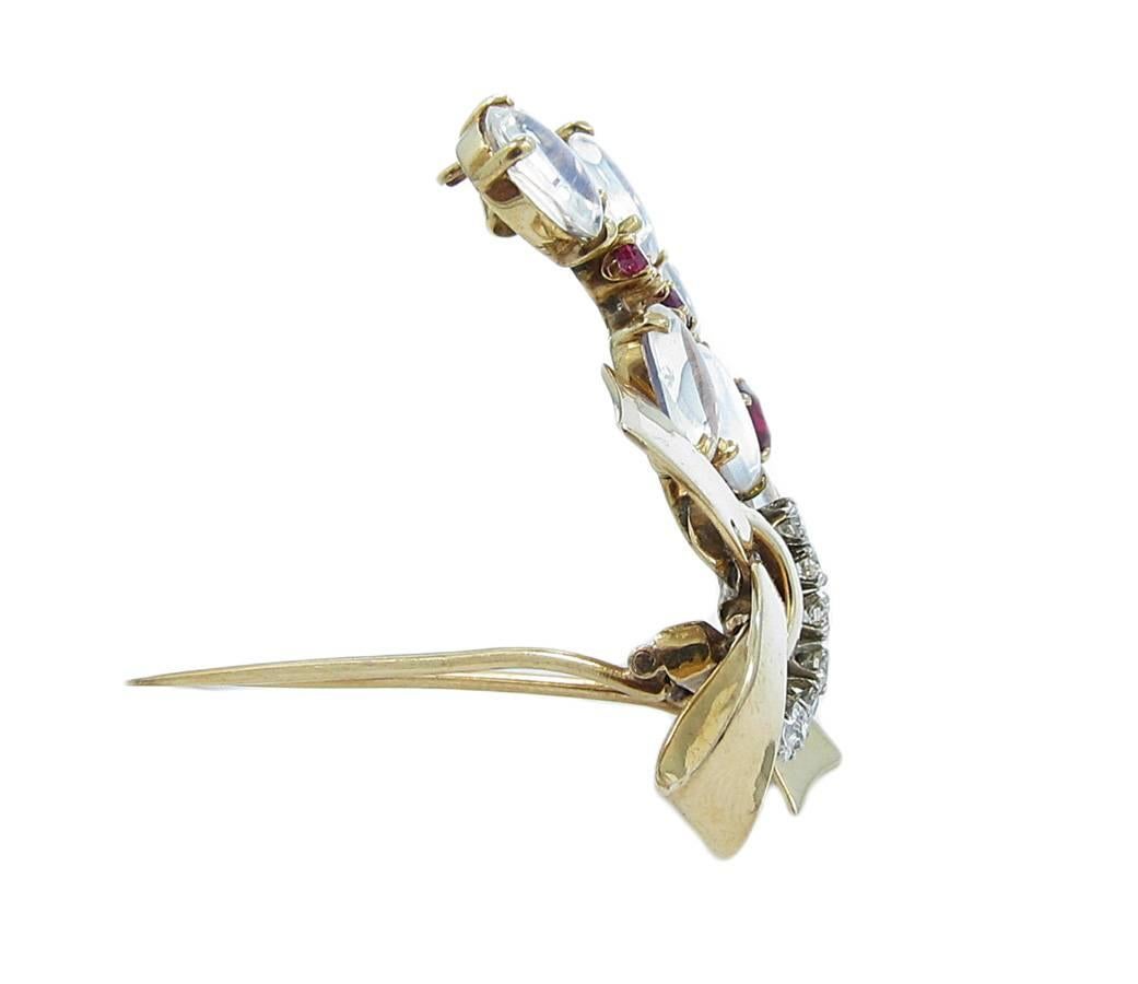 This Yellow Gold  Raymond Yard Design Brooch features a bow pattern and contains approximately 14.00cts of Moonstone, .90ctw of Rubies and .56ctw of Round brilliant cut diamonds. Quality of the rubies is amazing with a deep red color. Each oval