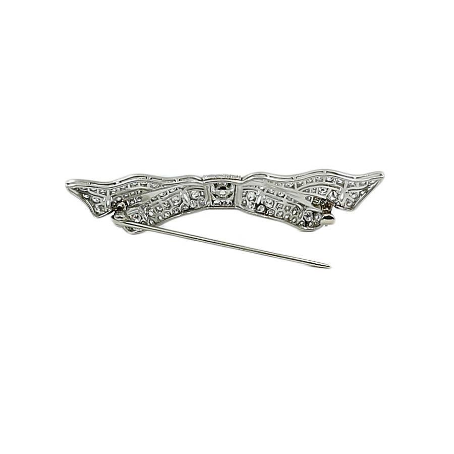 Platinum Art Deco diamond bow pin. The old euro cut diamond G-H/VS weighs approximately 0.40 carats total weight. The single sut diamonds G-H/VS weigh approximately 1.25 carats total weight. The pin measures 2.375 inches in width and weighs a total