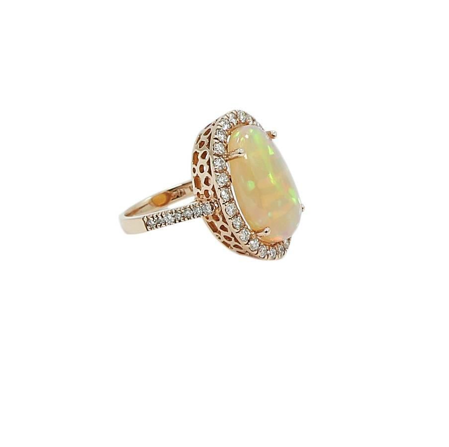 14k rose gold halo diamond and opal ring. The oval opal weighs 6.92 carats total weight and the 40 round diamonds H VS weigh 1.15 carats total weight.  The ring sits at a size 7.25 and weighs a total of 8.5 grams. It measures 1.00 inch in height and
