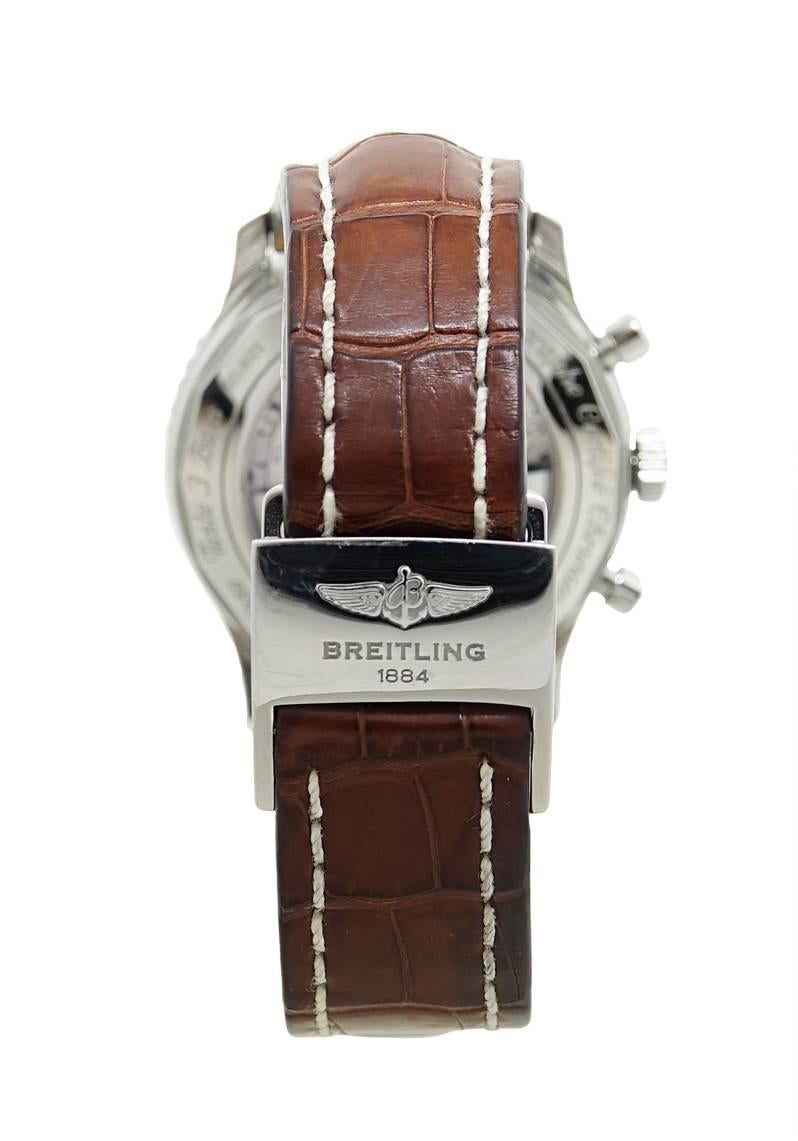 This Breitling Stainless Steel Navitimer 01 Model AB0127 Mens Watch Is Stainless Steel With A Black Dial With White and Red Detailing. The Case Is Stainless Steel with Sapphire Crystal Back and Measures 46mm. The watch Is On A Light Brown Crocodile
