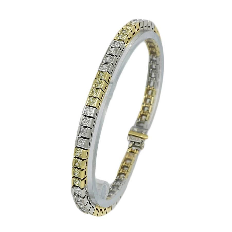 Platinum tennis bracelet with white and yellow diamonds. It has 56 diamonds weighing approximately 12.0 carats total weight. It measures 7.5 inches in length and weighs a total of 32.8 grams. The bracelet is in excellent condition.