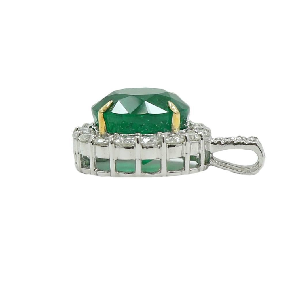 18k white gold diamond and round emerald pendant. The diamonds weigh 1.74 carats total weight and the emerald weighs 10.67 carats total weight. It measures 0.75 inches in width by 0.75inches in length. The pendant weighs 7.5 grams and is in