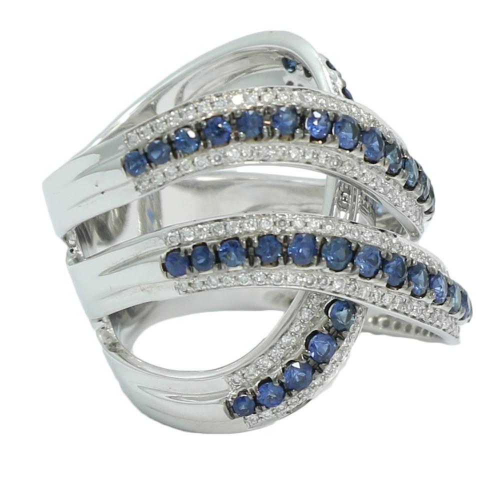 14K White Gold Wide Cross Over Diamond and Sapphire Ring. The Diamonds Weigh 1.45 Carats Total Weight and The Sapphires Weigh 1.75 Carats Total Weight. The Ring Sits At A Size 7.5 and Weighs A Total Of 11.8 Grams. 