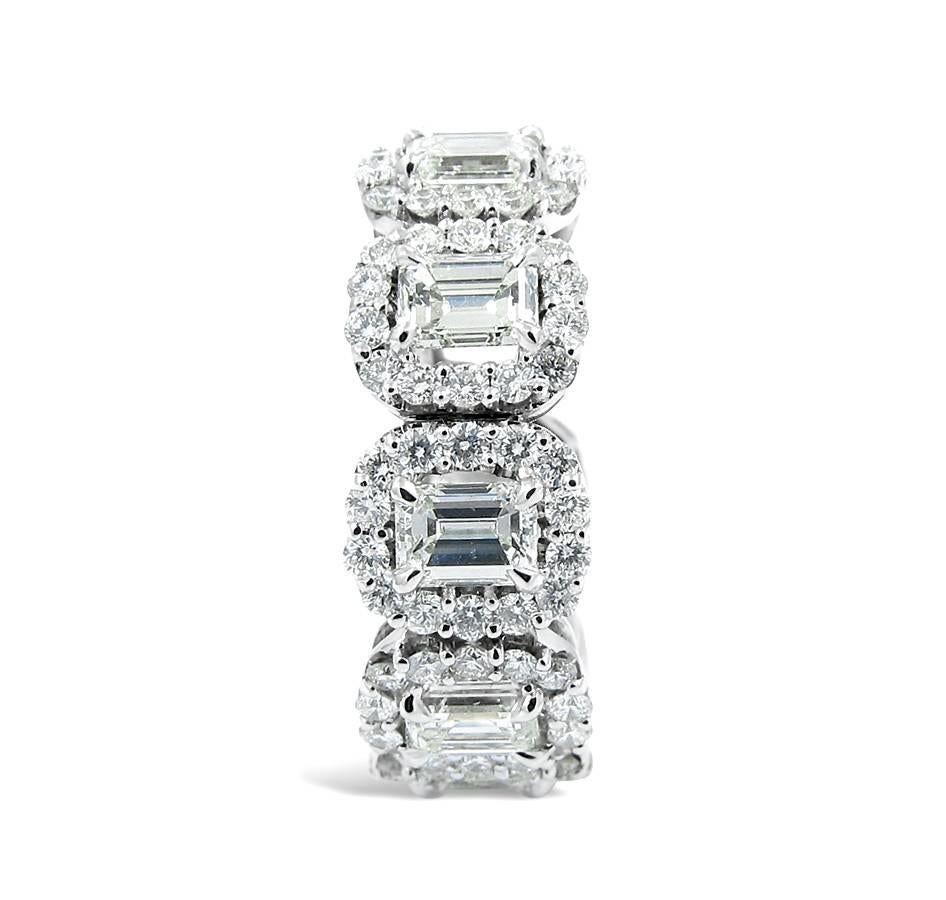 This beautiful eternity band stands out with each diamond having its own halo of round brilliant diamonds. This ring holds 9 emerald cut diamonds which equal 3.33 carats total weight. The surrounding round diamonds equal 1.88 carats total weight.