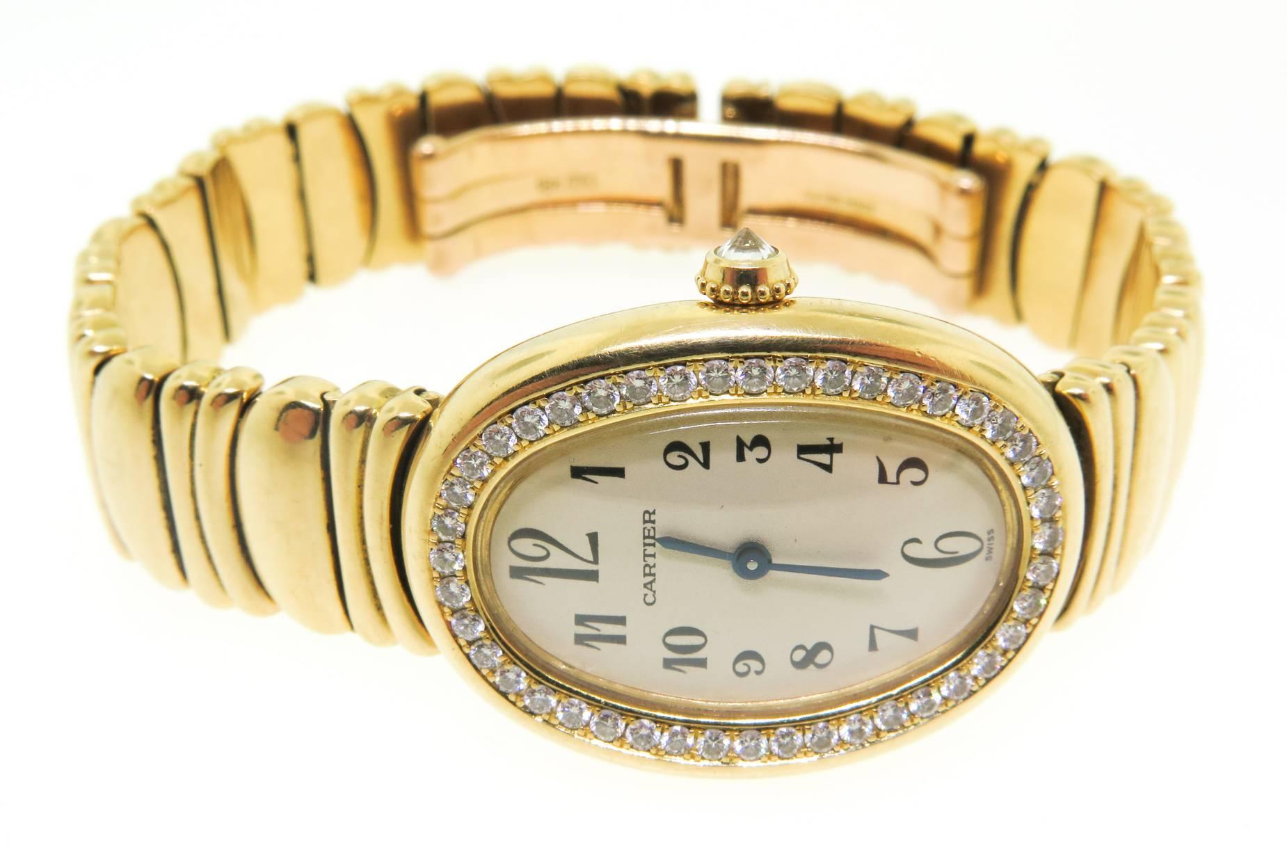 Ladies' 18K yellow gold Cartier Baignoire Swiss made watch with smooth Diamond bezel, white flat dial, black hands, black Arabic hour markers, push/pull crown. Solid 18K yellow gold link bracelet and double deployant closure. Water resistant to 30