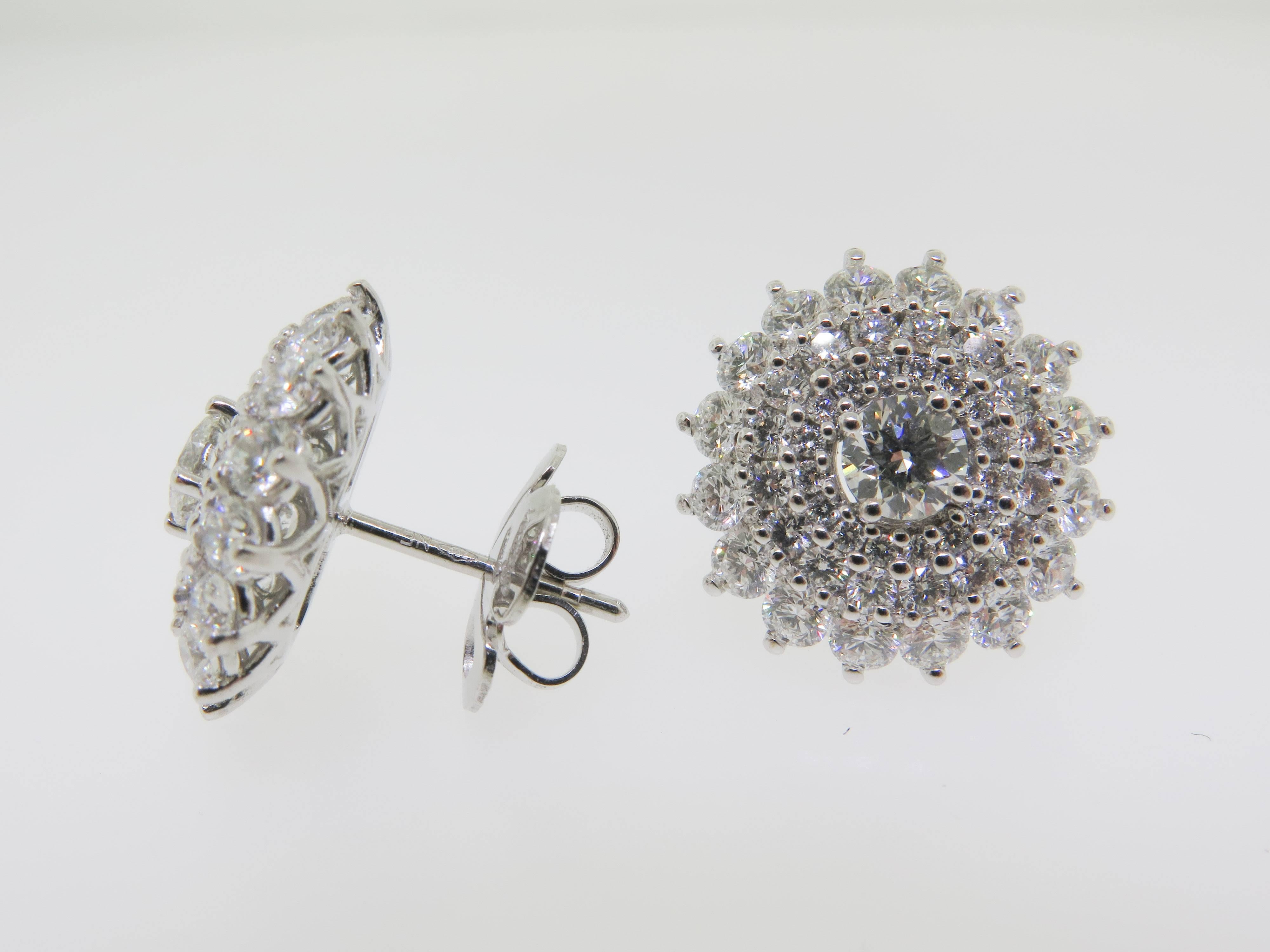 These gorgeous pair of earrings, set and hand crafted in 18K white gold. Bright white round cut diamonds, look brilliant in these cluster earrings. Approximate total weight 4.58 carats. These are earrings that do not require a special occasion.