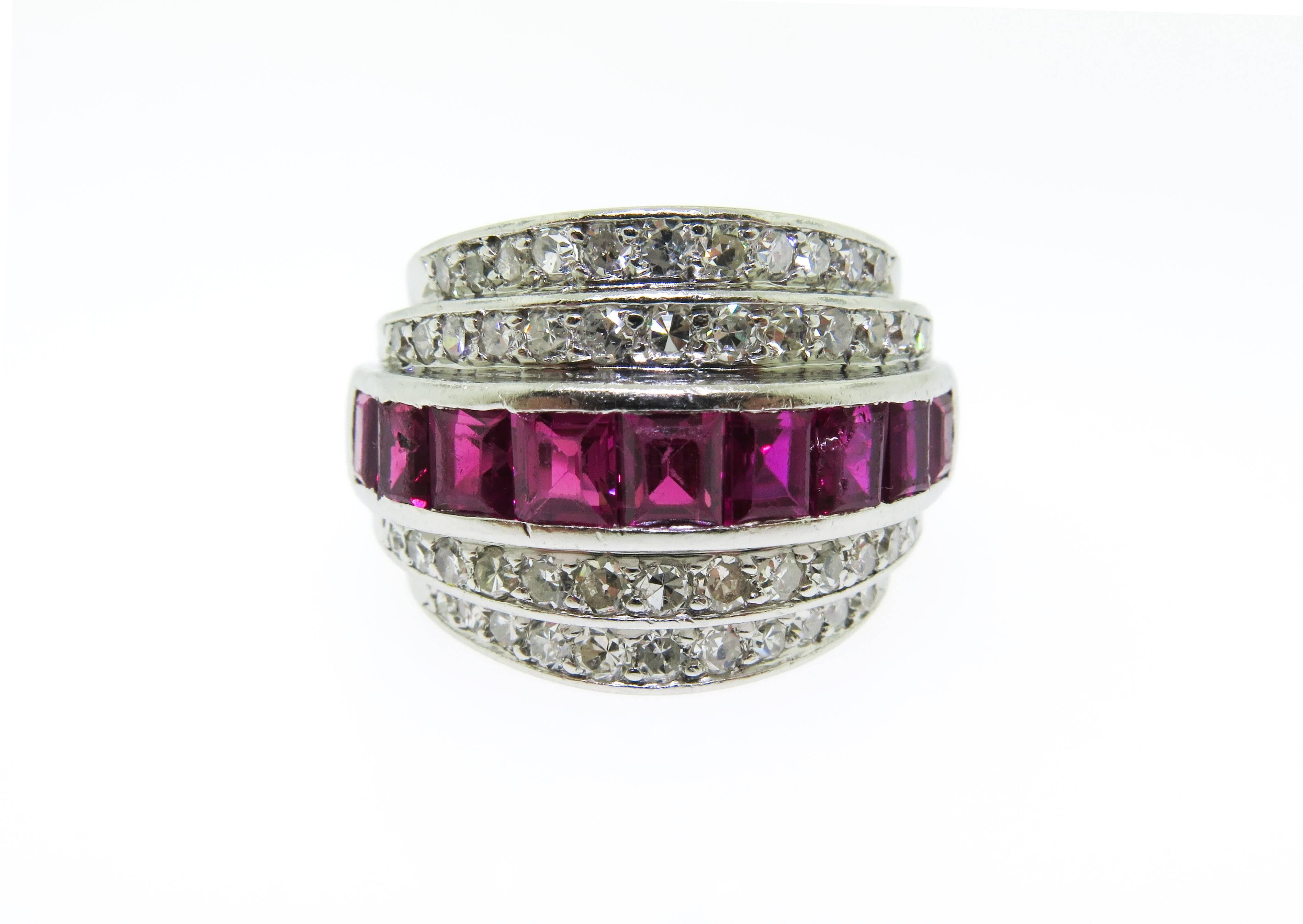 Circa 1960 This slightly domed designed ring with vibrant channel-set princess cut rubies weighing approximately 1.00 carats, perfectly positioned between two rows of beautiful round diamonds totaling approximately 1.50 carat,  G - H color, SI