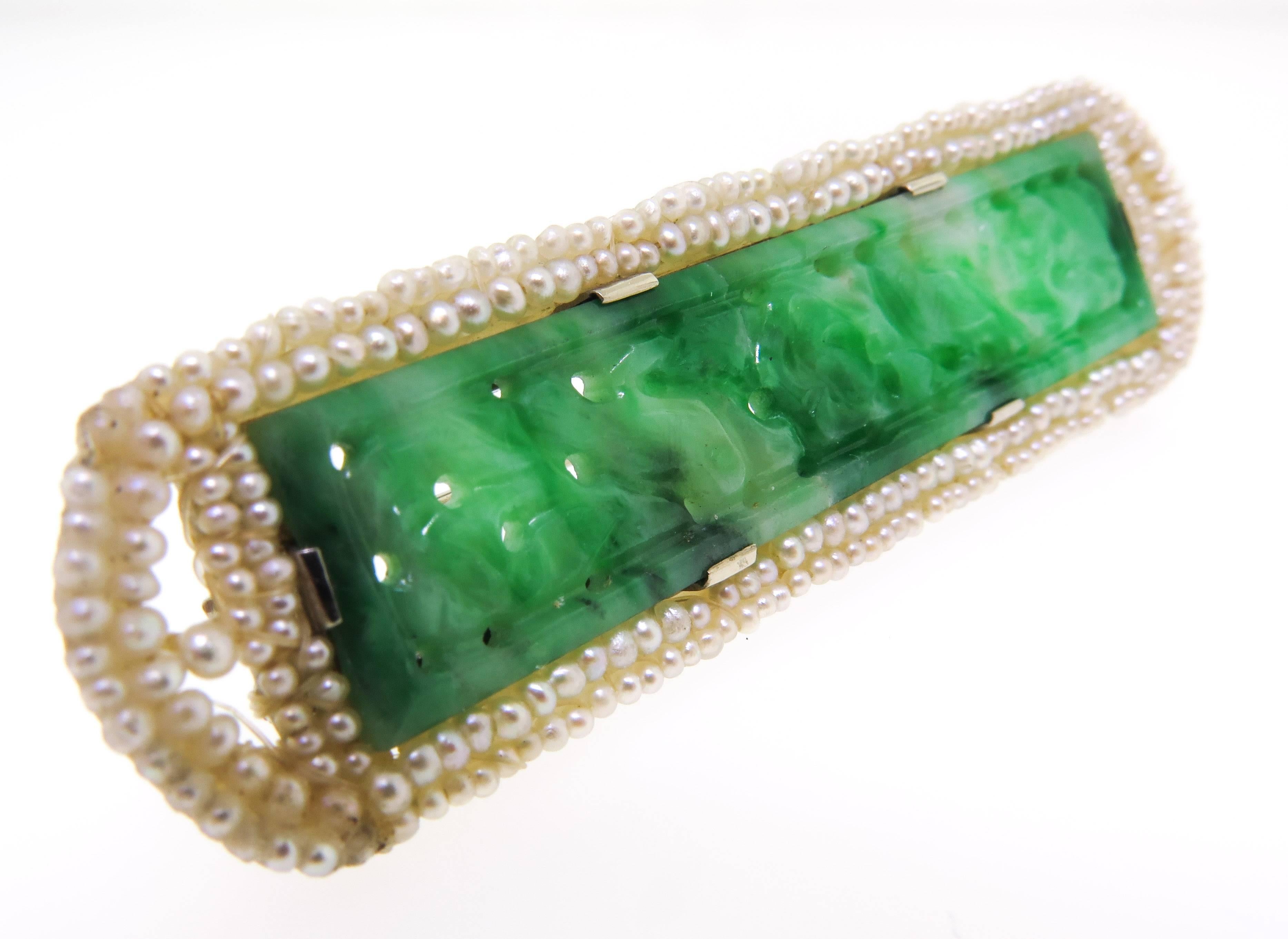 This fine and impressive vintage jade brooch is part of our estate jewelry collection.
The bar style brooch features a pierced decorative design jade, framed by two rows of natural baby sea pearls set in a white gold setting.
Measures 2.5 inches