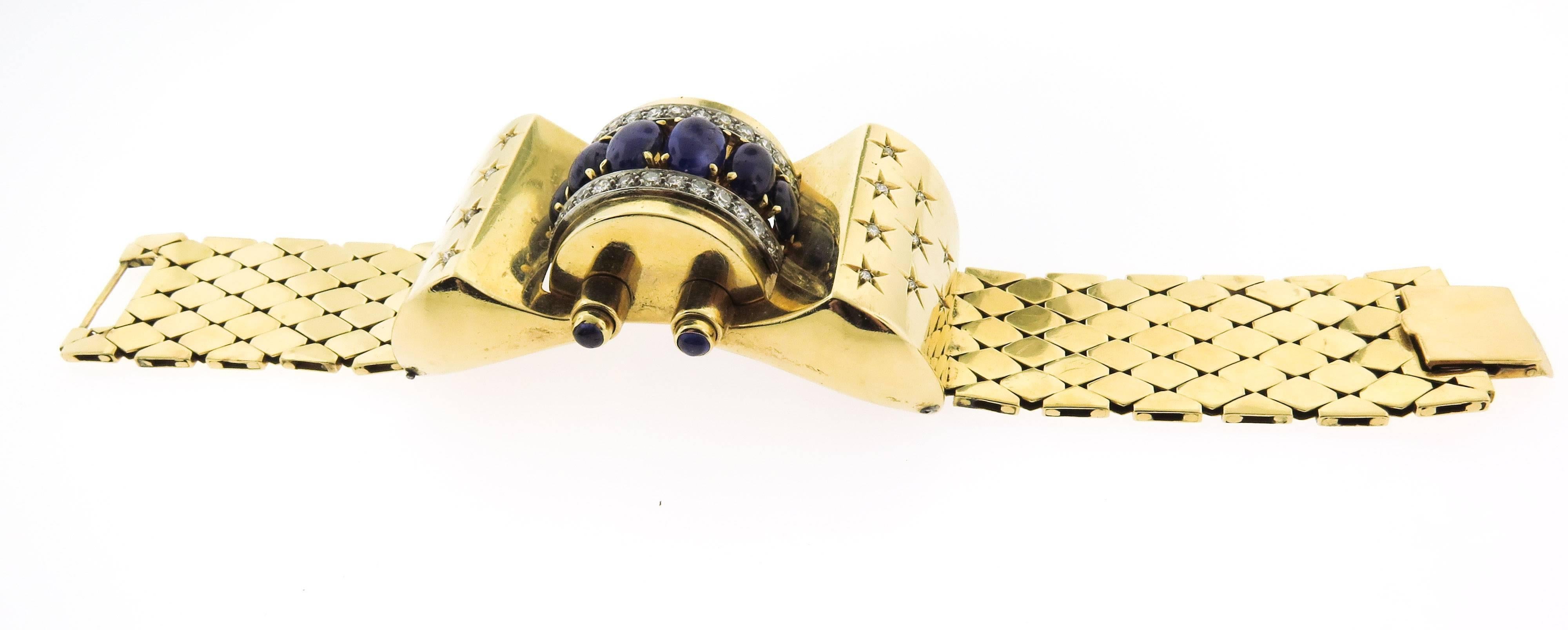 This exceptional and impressive vintage sapphire and diamond bracelet has been crafted in 18k yellow gold. This typical Art Deco design consists of two mesh and three center links accented with seven oval cabochon sapphires between two rows of