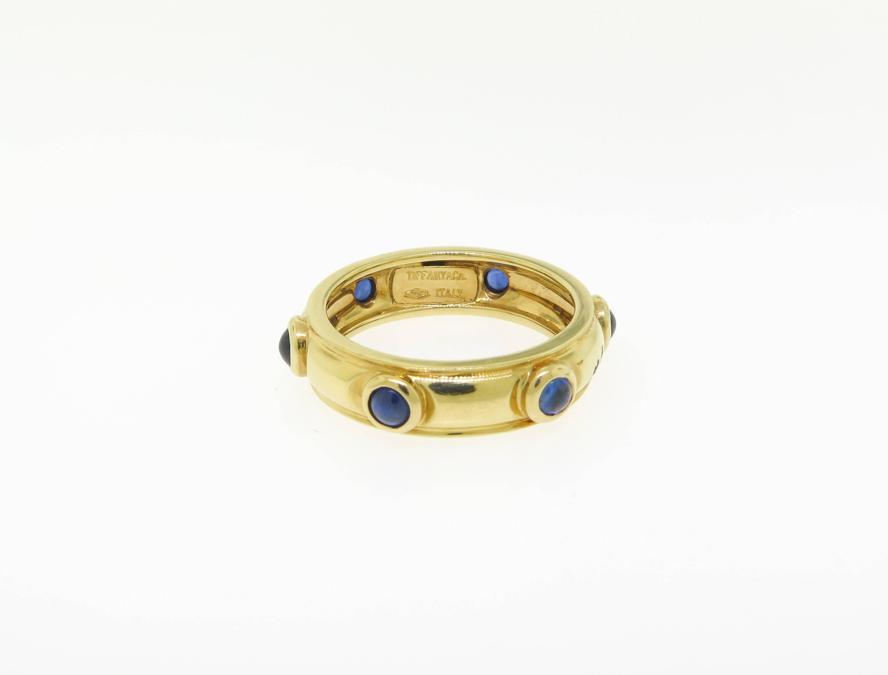 Chic ring created by Tiffany & Co. Made of 18k yellow gold and set with 6 cabochon sapphires. The ring is size 6.75. It is stamped with Tiffany & Co. maker's hallmark. Beautiful and wearable ring as a stackable, or to enjoy on it's own. 