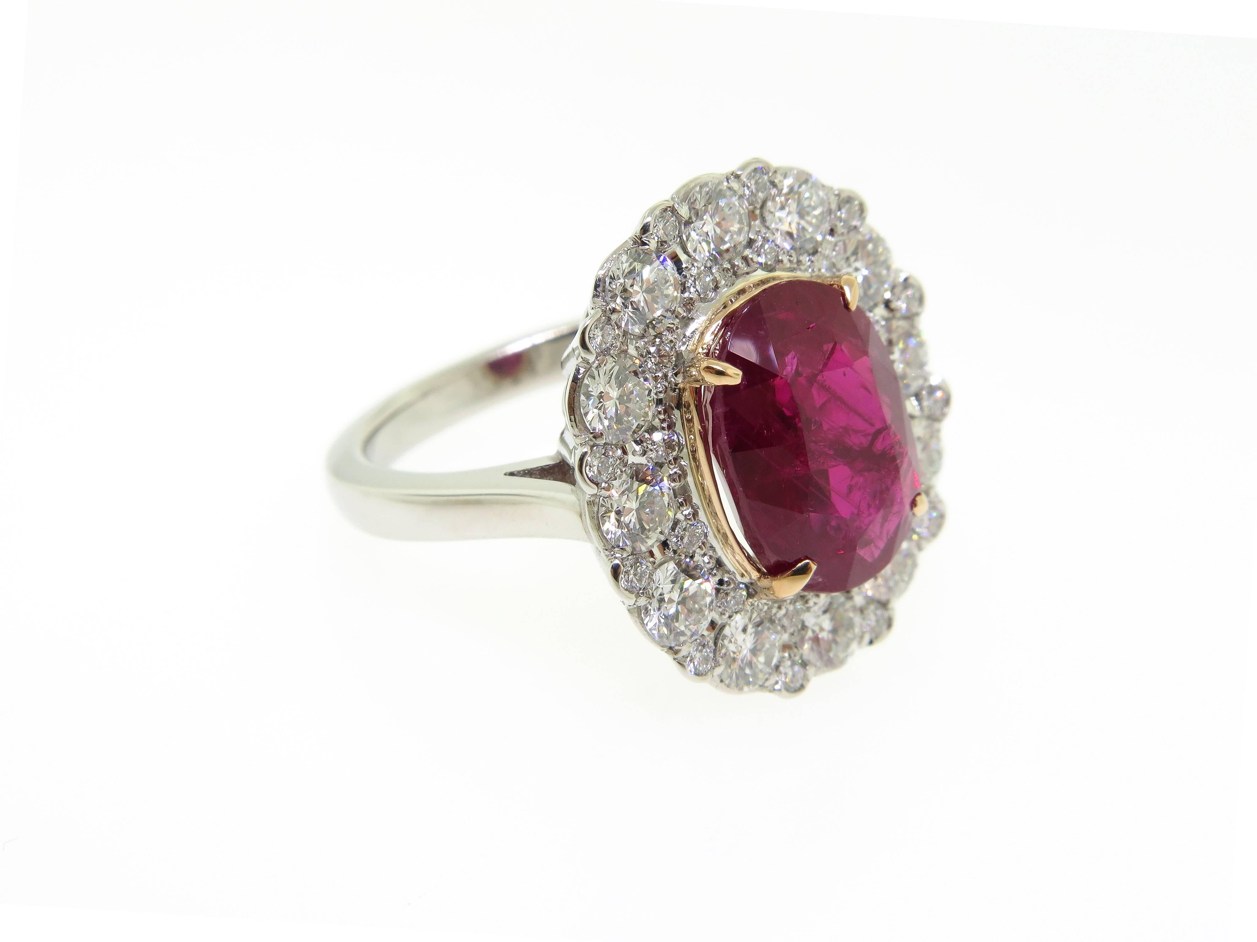 Absolutely stunning platinum ring featuring an oval cut natural burma ruby weighing approximately 5.02 carats accented by 11 round brilliant cut diamonds weighing approximately 2.00 carats total, G color VS-SI clarity.  The ring is a size 5.75 and