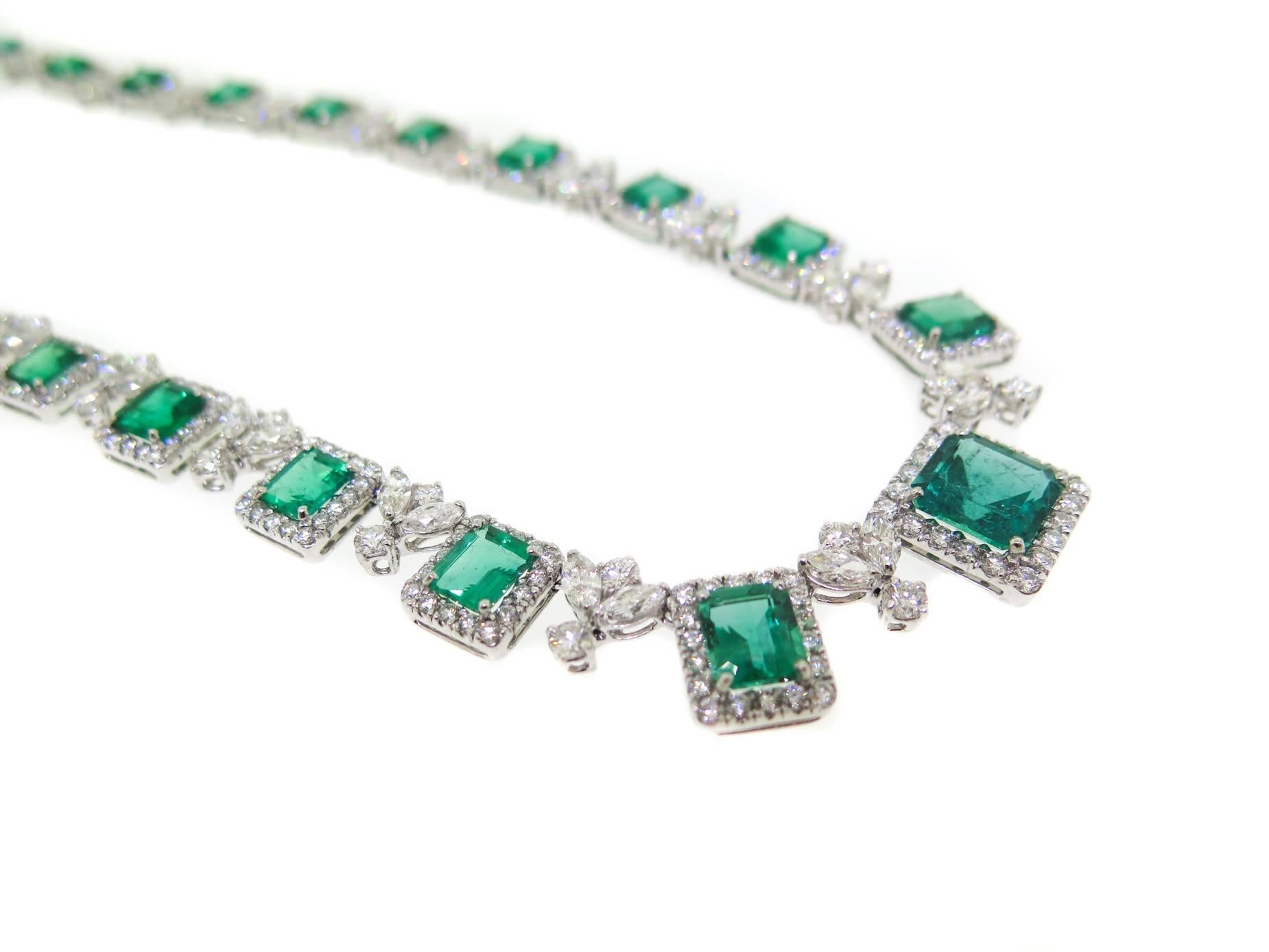 A chic and elegant necklace consisting of 23 emerald weighing 30.10 carats surrounded by white diamonds weighing approximately 20.41 carats, hand-made in platinum, hidden diamond box clasp stamped PT950, measures 16