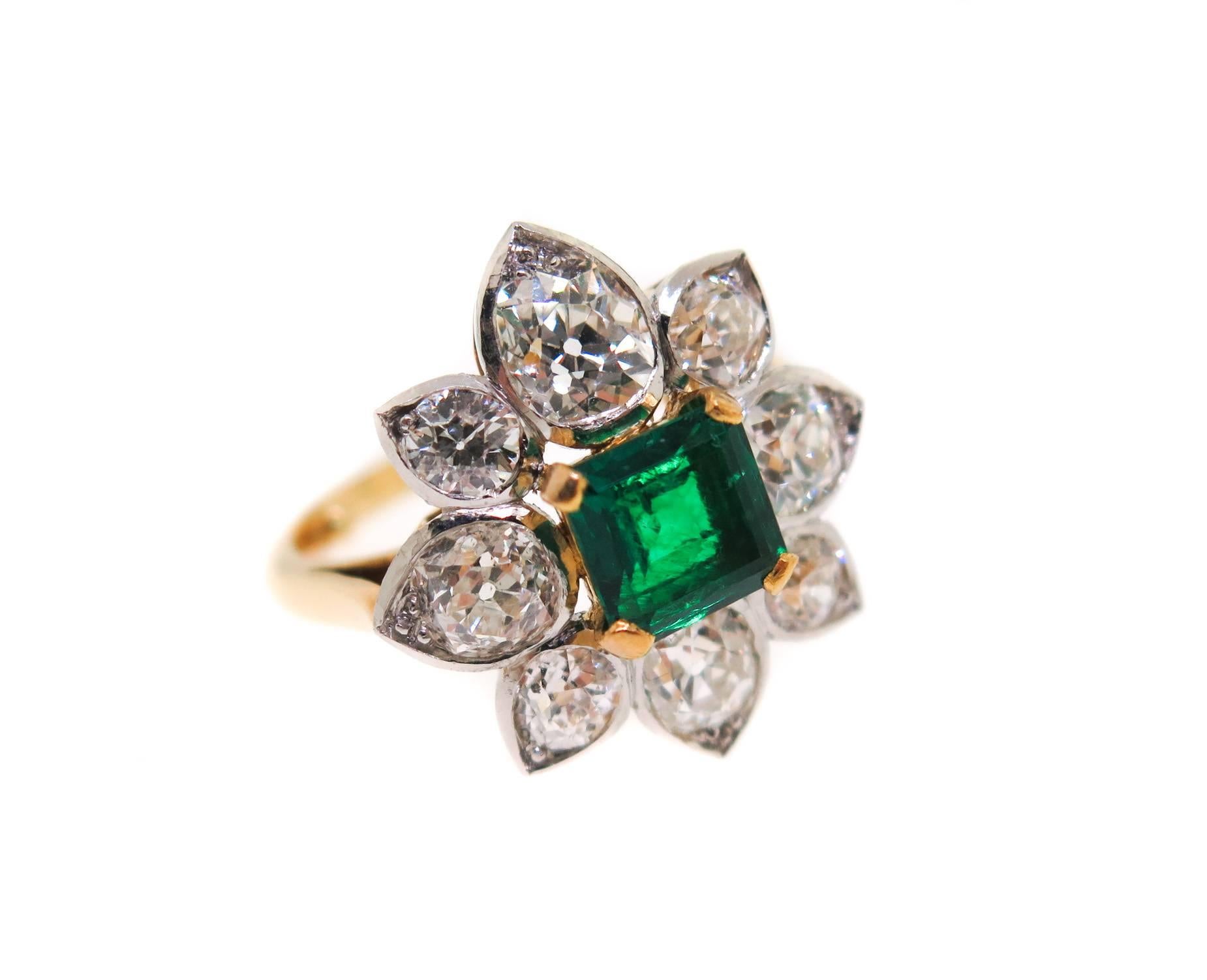A gorgeous ring, centered with a very fine princess-cut emerald (6.5 mm, approximately 1.50 carats) surrounded by a cluster of 8 old european cut diamonds. Estimated total diamond weight is approximately 2.50 carats. Crafted in 18K yellow gold and