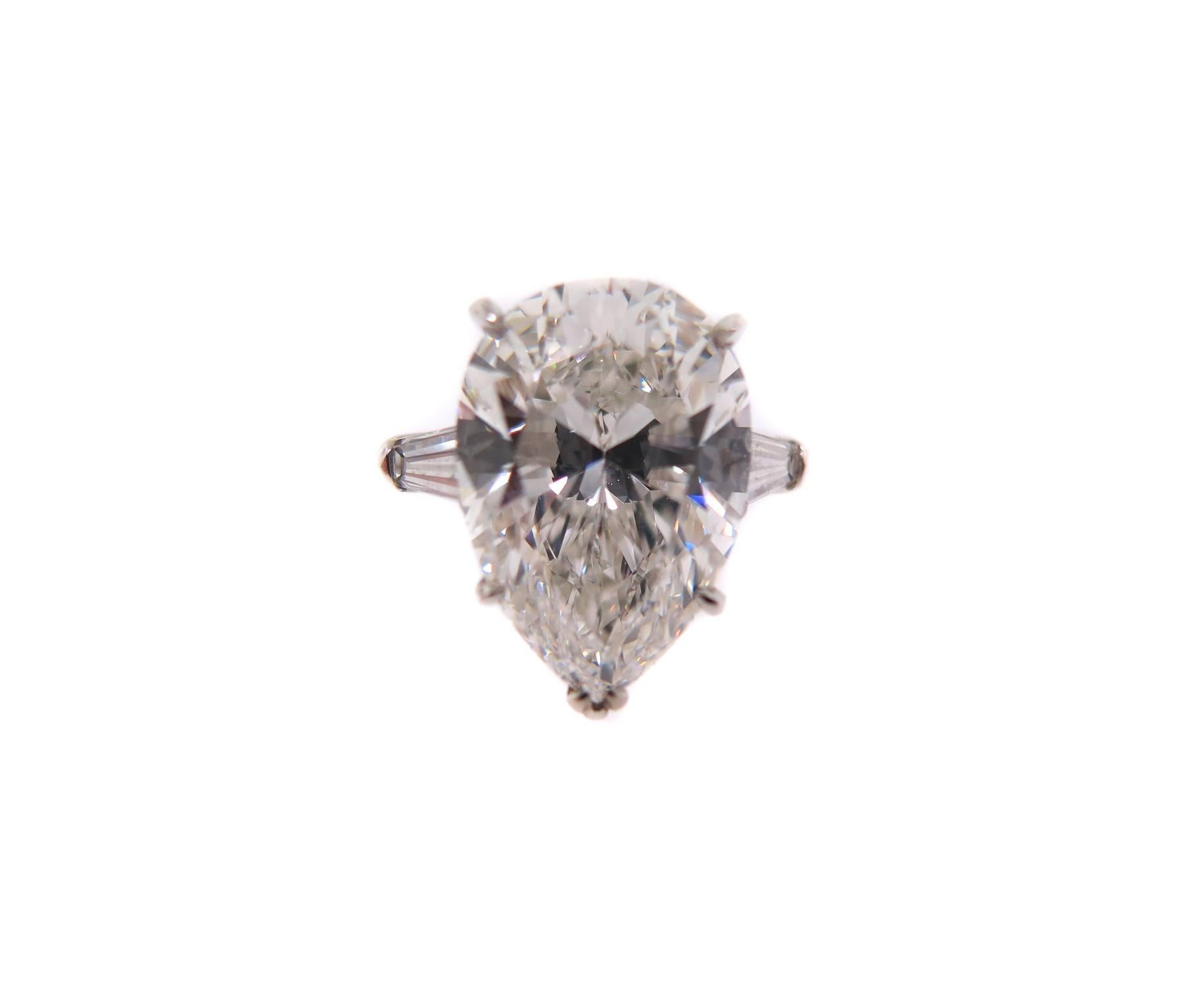 Eine herrliche Harry Winston Platin Diamant Verlobungsring:: atemberaubend schön:: in Platin gefertigt:: mit einem 6::83 Karat Pear förmigen Diamanten Zentrum:: flankiert von einem verjüngten Baguette Diamant auf jeder Seite. 
Dem Ring liegt der