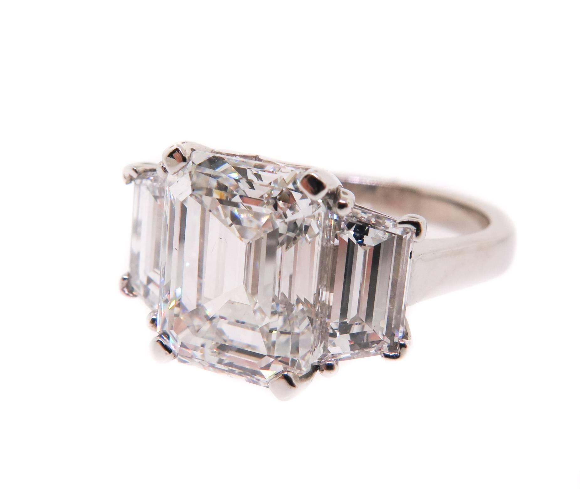 Handcrafted three-diamond platinum ring. 
Set with a 5.47 carat Emerald Cut Diamond, F color, VS2 clarity GIA certified. Flanked by two trapezoid cut diamonds with a total weight of 2.08 carats.
The three stones flow beautifully between one