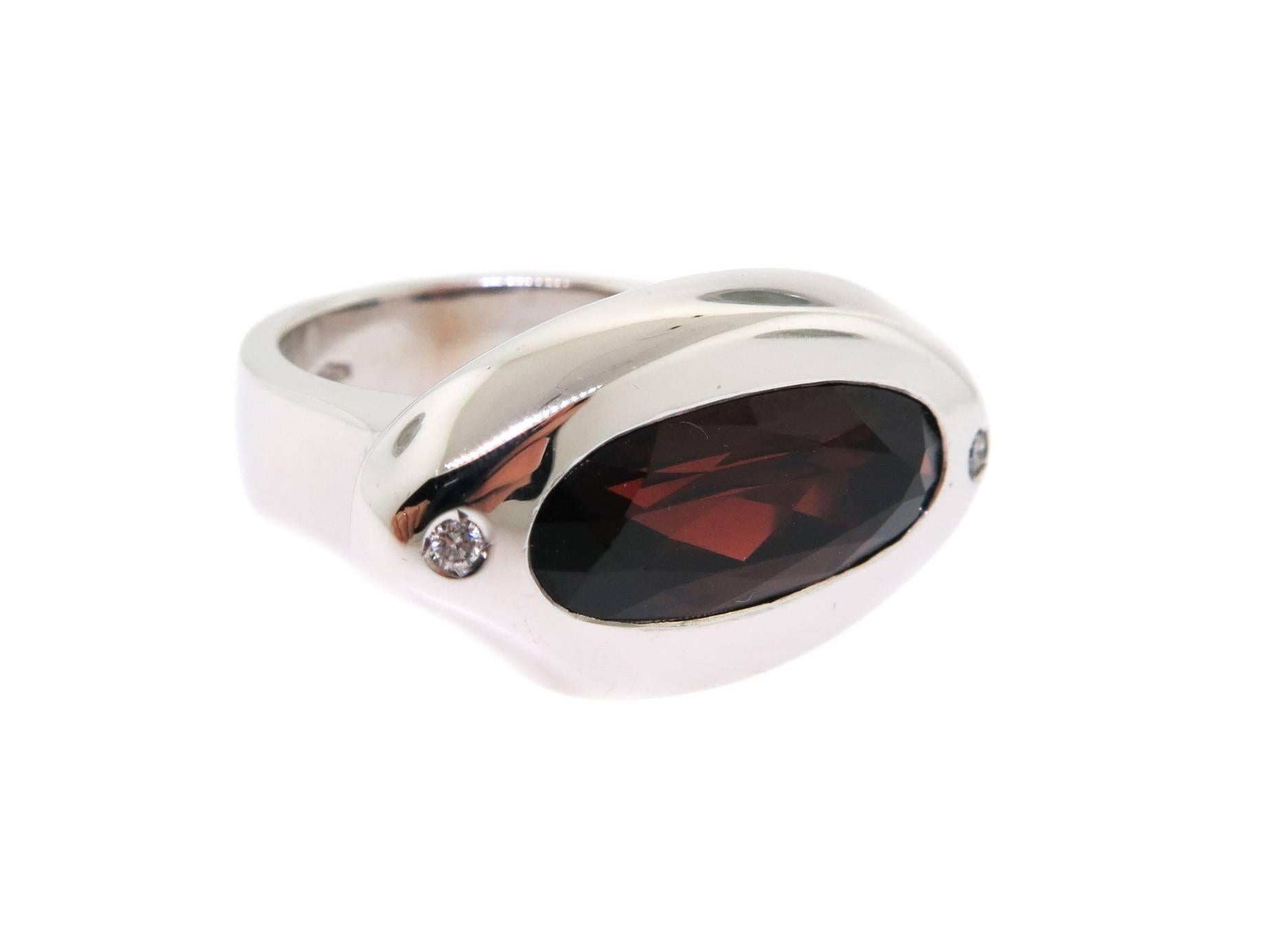 Eye-catching and compelling... wonderfully set garnet in a very attractive smooth 18 karat white gold bezel, exceptional design by Manfredi.
Ring finger size is 6.5