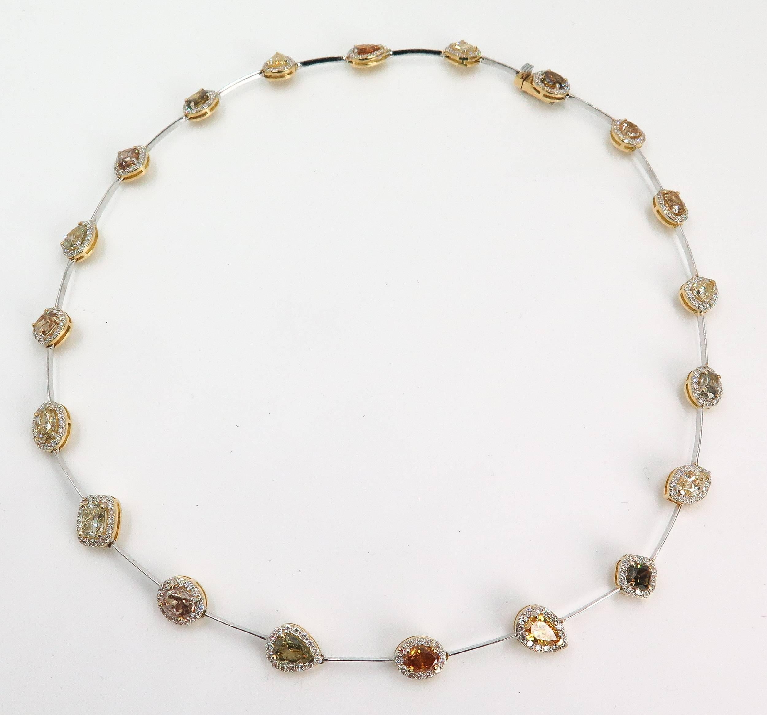 Stunning necklace composed of 20 natural fancy colored diamonds in different shapes, weighing 16.98 carats surrounded by round brilliant cut diamond halo and handcrafted in 18 karat white and yellow gold. 
Scientists believe these exquisite gems are