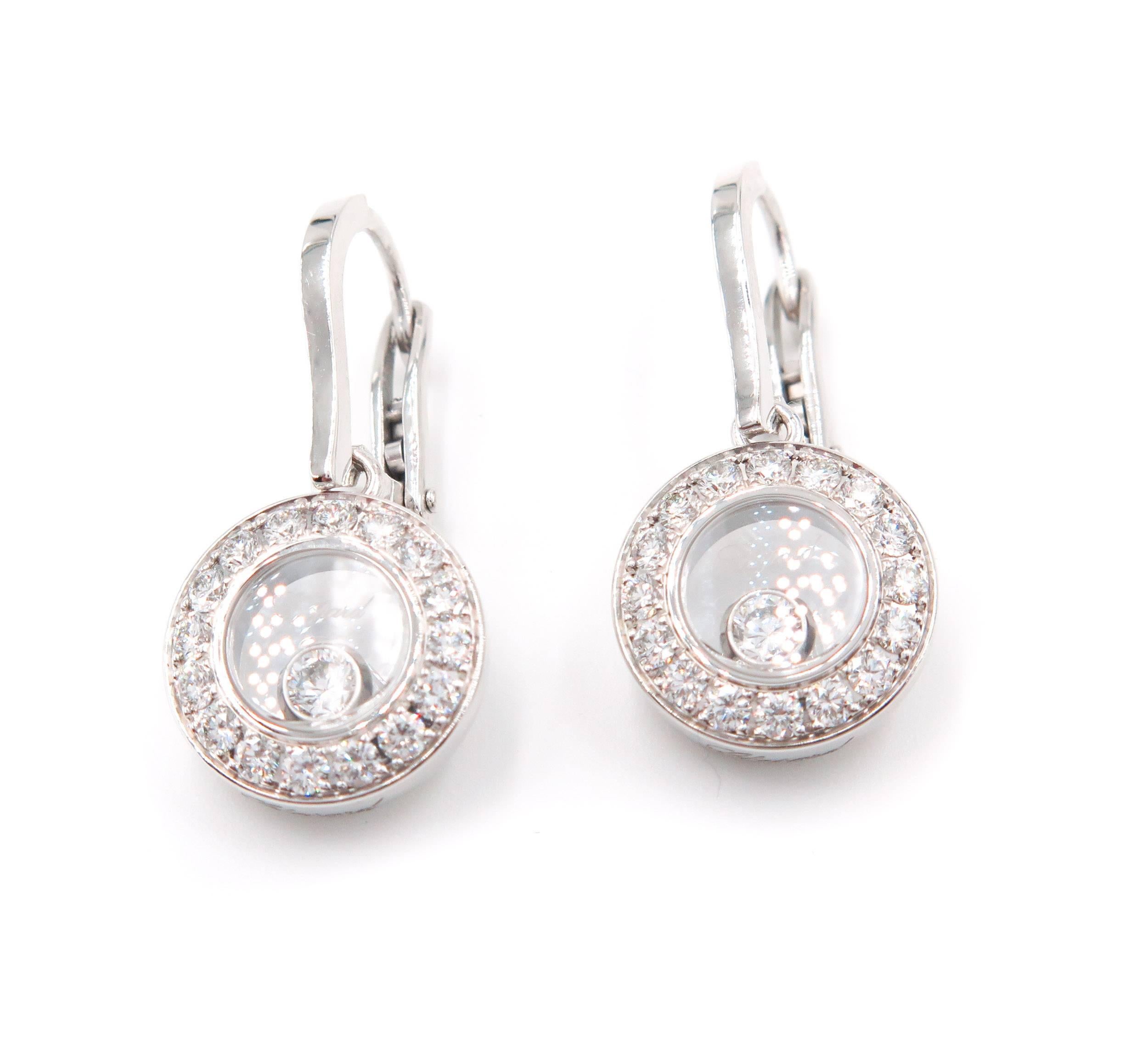 This Happy Diamonds  is a charming take on the classic diamond drop earrings. The delicate round motif of these earrings in 18 karat white gold holds the signature moving diamond that dances between two sapphire crystals, its sparkle reflected by