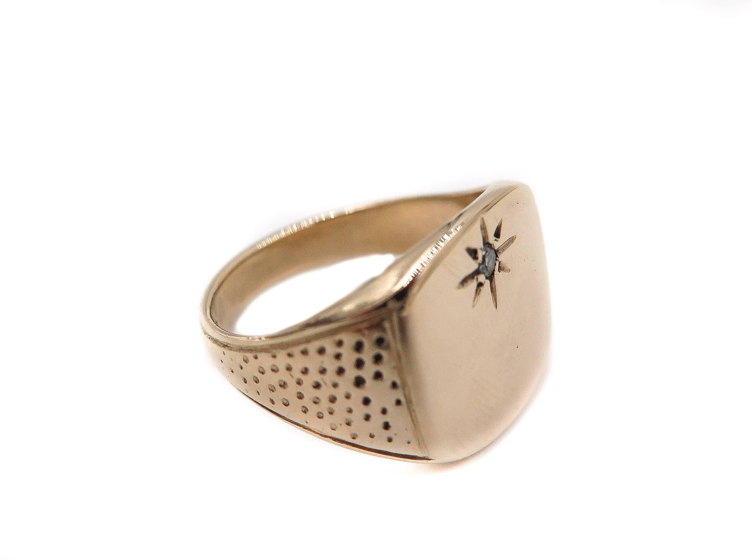 A fine and impressive signet ring handcrafted in 14K yellow gold; part our gent's jewelry and estate jewelry collection.
The cushion shaped face of this signet ring is embellished with a inset round diamond depicting a star.
The flared dotted ring