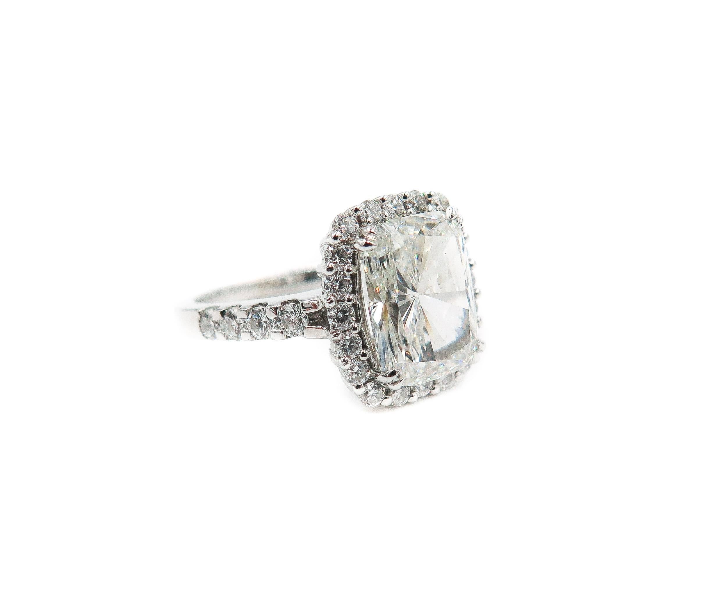 This captivating engagement ring of classic charm and sophistication is crafted in solid platinum. 
Elaborately designed as a stunning halo and centered with a prominent cushion-cut diamond certified by GIA, weighing 4.02 carats, H color, VVS2