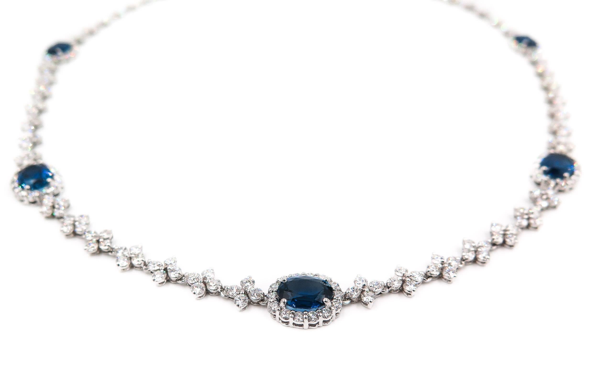 This elegant 18 karat white gold necklace designed by Leo Pizzo features 5 oval sapphires with a total carat weight of 7.08 carats that have exceptional cut and color. Each sapphire is adorned with a diamond halo. 
The diamonds have a total carat