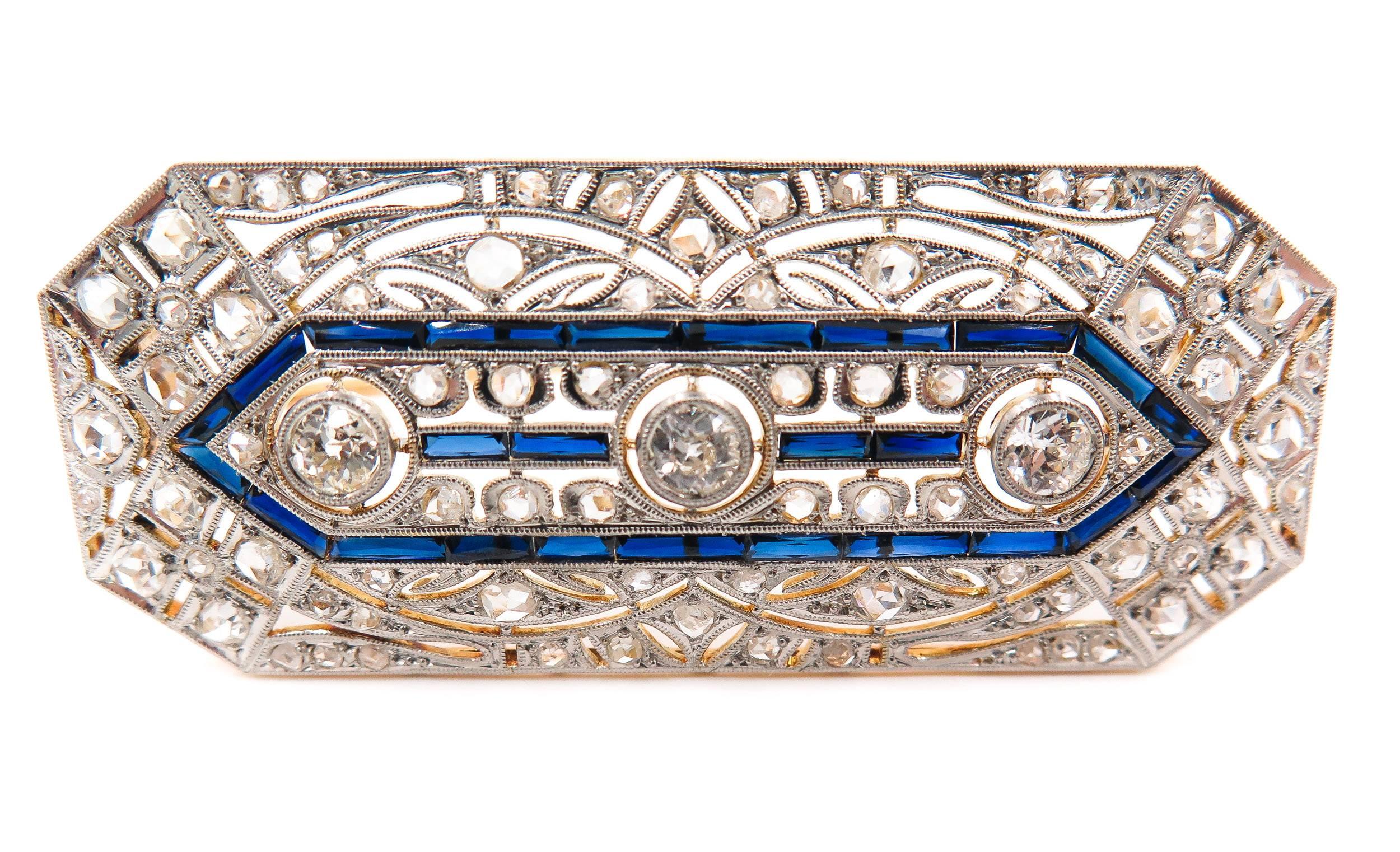 Art Deco diamond and sapphire crafted in platinum and 18K yellow gold brooch. 
Designed with 3 rose-cut diamonds framed by similarly cut diamonds and blue sapphire, an excellent quality jewel, high craftsmanship and outstanding beauty, characterized