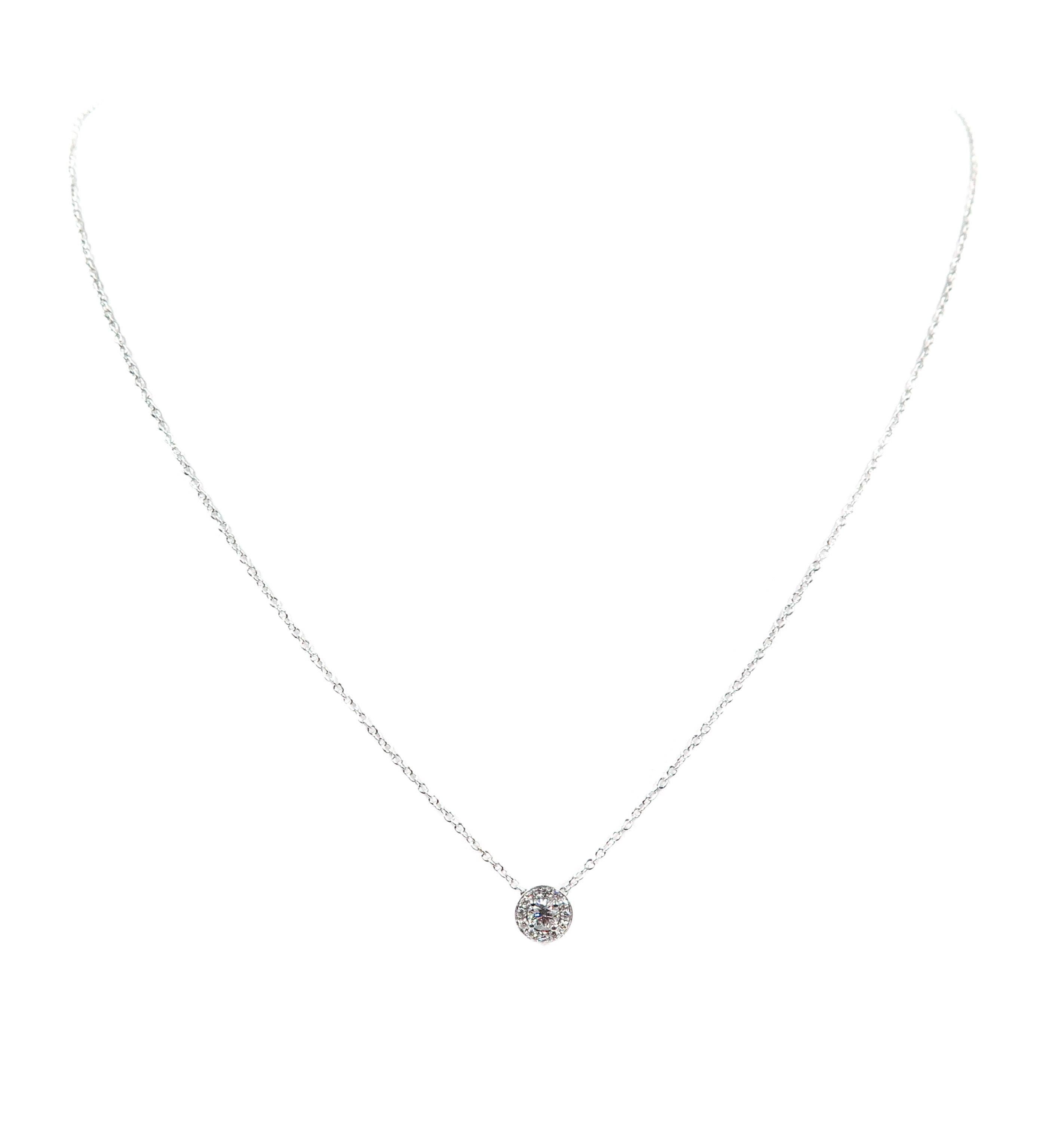 Let this gorgeous diamond pendant glitter and gleam on you. 
Handcrafted in 18k white gold in a simple halo design, suspended by an 18 inch cable chain. 
A classic and sophisticated look that will make a staple piece in your collection.  