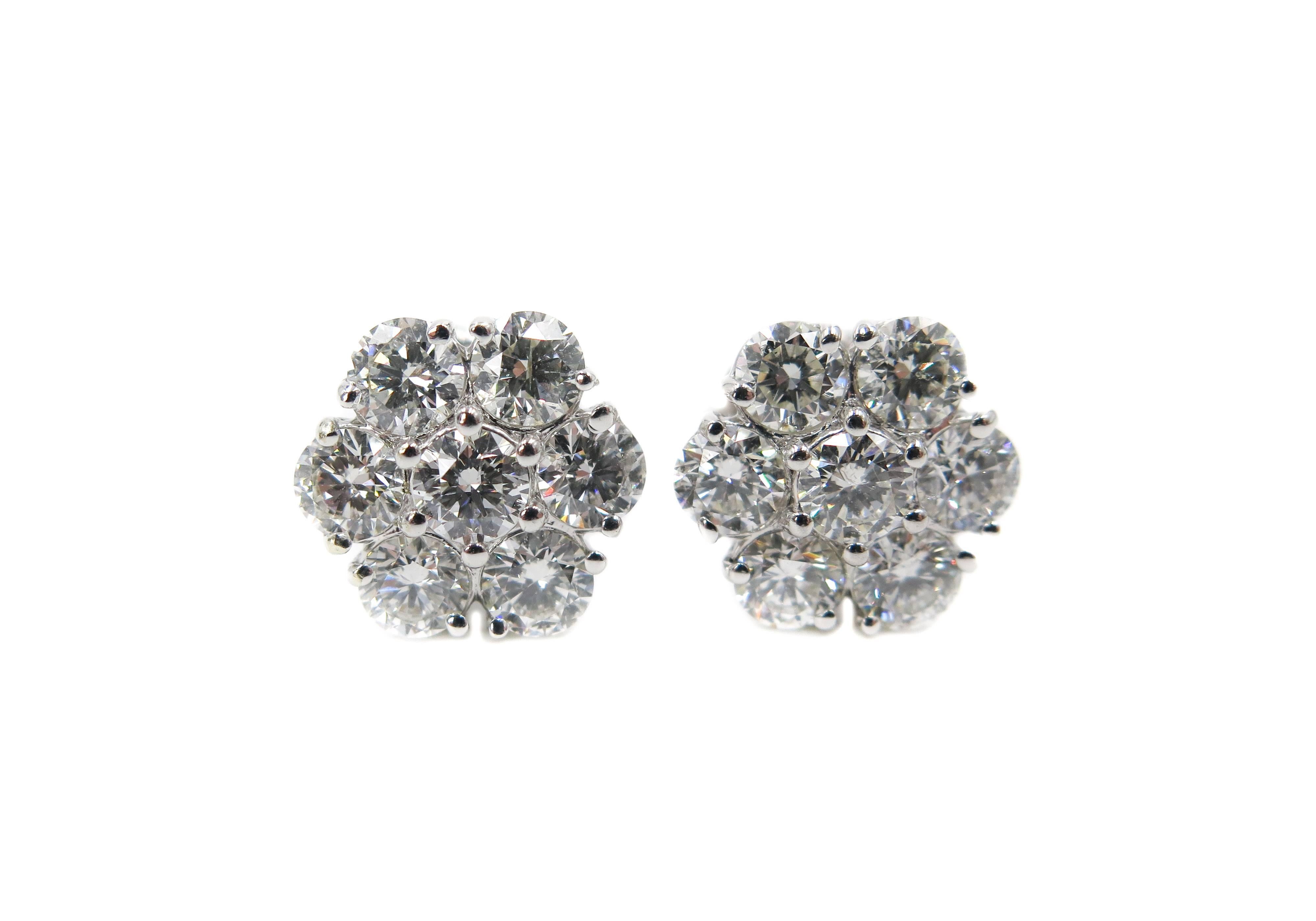 Diamond flower cluster stud earrings in 18k white gold. 
Fourteen matching near-colorless round brilliant-cut diamonds weighing 4.70 carats total. 
12 round diamonds 4.20 carats and 2 round diamonds in the center 0.50 carats (0.25 carats each). 
The
