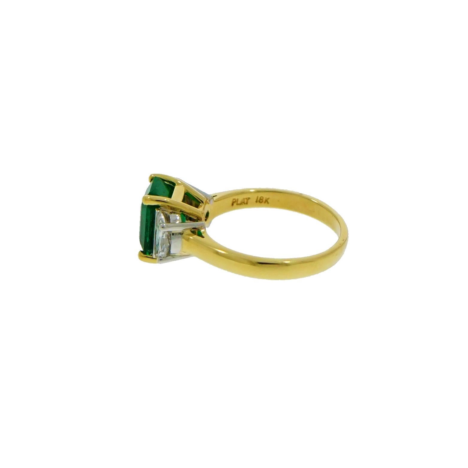 This Emerald and Diamond Ring, was created as the traditional 3 stones ring with the passion of any handmade work and combined for their simple shape. 
The Emerald is set in 18k Yellow Gold and adorned with half moon shaped diamonds set at each side