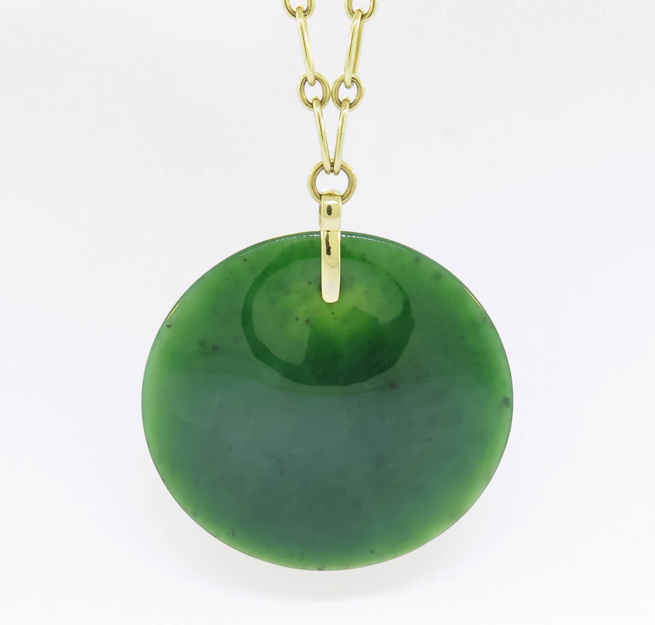 Round pendant in jade by famous designer Elsa Peretti for Tiffany on a 18 karat yellow gold link  20