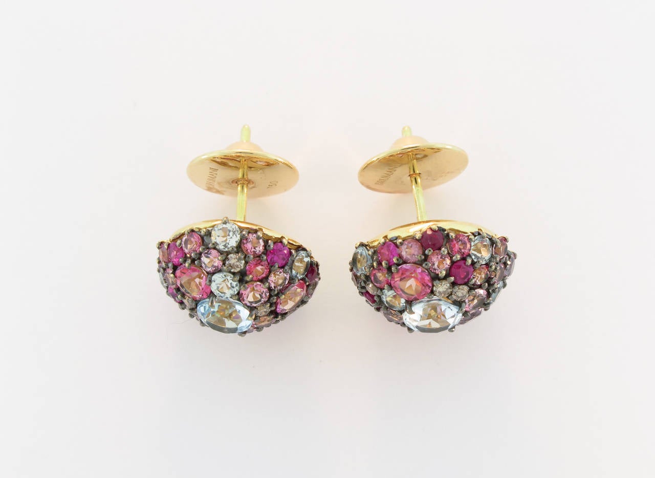 This set of earrings is part of the Baobab Collection. Beautiful cluster of blue Sky Topaz, Diamonds, Rubies and pink Topaz set in 18K yellow gold is surely a versatile piece that can accessorize any wardrobe.