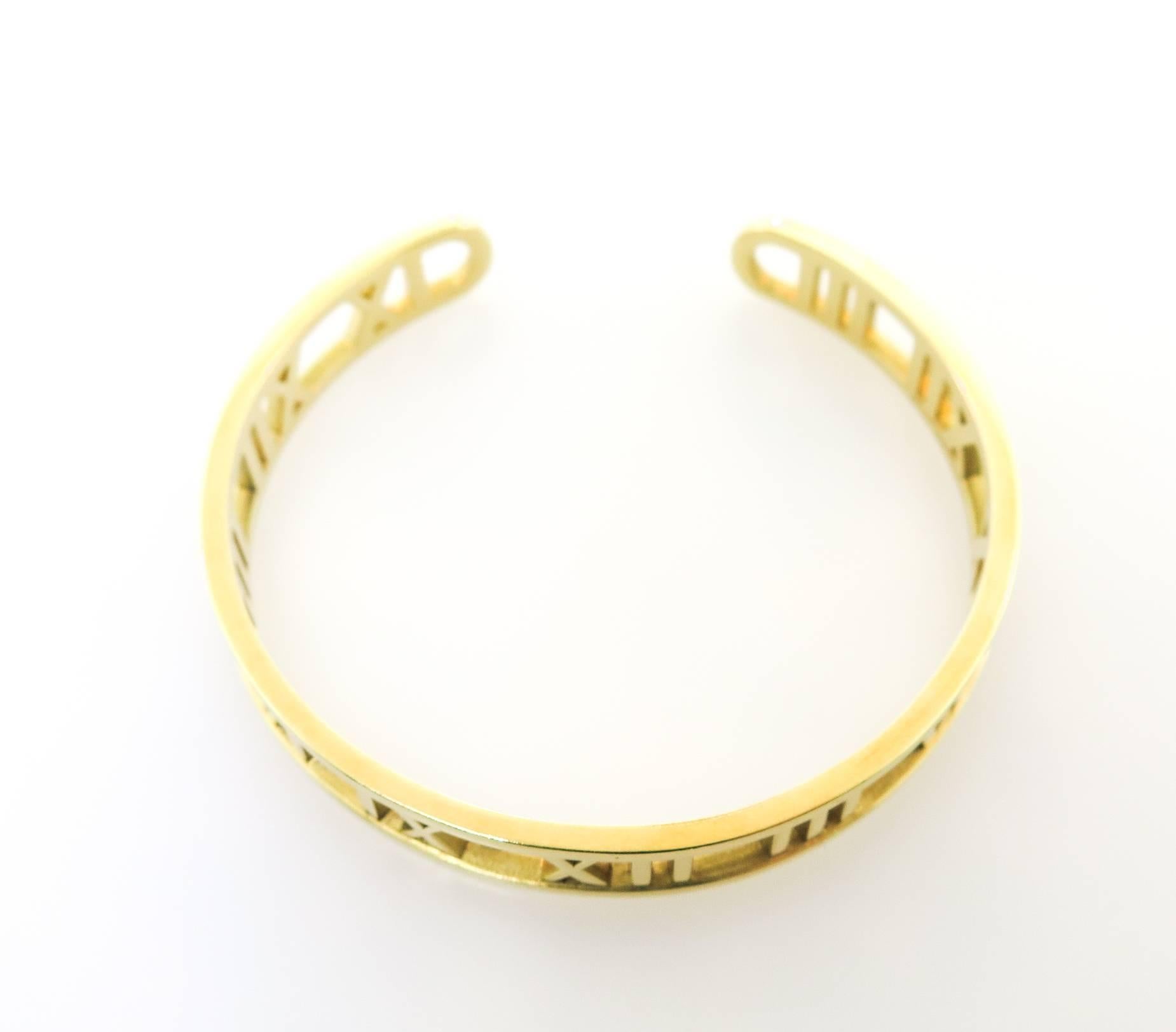 The beautiful Tiffany & Co cuff bracelet is from the Atlas collection. This bracelet  features a bold and distinctive roman numeral motif and sleek lines. Its dated 2003. It has a good weight and feels great on.  Measures 6 inches diameter x 10mm