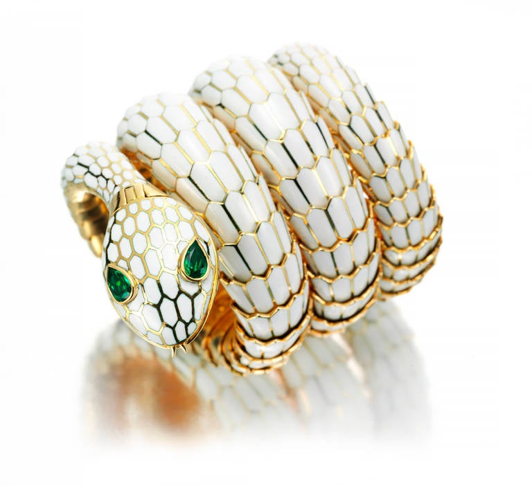 Bulgari lady's 18k yellow gold, enamel and emerald serpent bracelet watch, designed as a snake decorated with white enamel and pear-shaped emerald eyes, the mouth opening to reveal a circular dial signed Omega, bracelet signed Bulgari, Italian assay