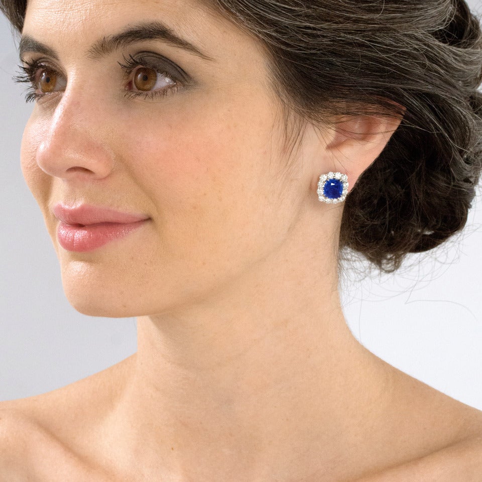 Circa 1950s, Platinum.  Set your ears ablaze with luminous cornflower blue sapphires embraced by brilliant white diamonds. These classic earrings are feature a 4.11 carat and 3.55 carat no-heat AGTA lab-certified sapphire (matched in size)