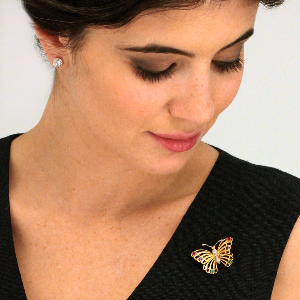Circa 1960s, 18k, Swiss.   Set with excellent quality diamonds, sapphires, rubies and emeralds, this French style silhouette motif butterfly brooch is lovely. The look is wearable everyday elegance. Known for classical styling and superior quality,