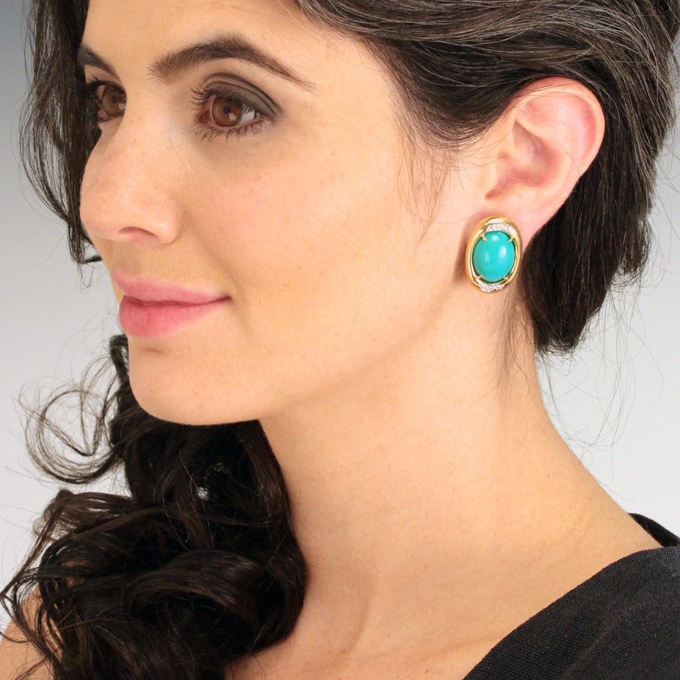 Circa 1980s, 14k, American.  The two exceptional Persian turquoise cabochons at the center of these lovely earrings are a vivid oceanic blue green. Their exuberant vibe is tempered by the tailored presentation of the polished gold frames. Well-made,