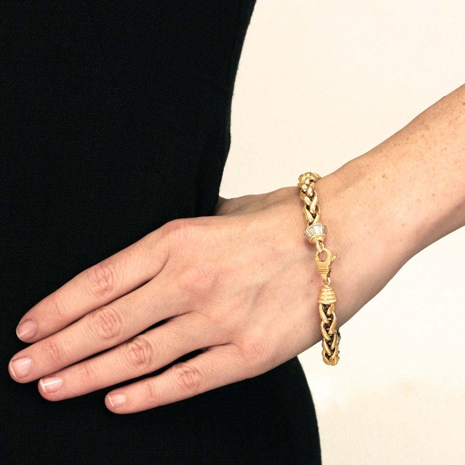 Circa 1970s, 18k, Venice, Italy. This delightful example of the wear-it-absolutely-every-day gold bracelet is a classic Russian braid design with a twist. Its oversized catch is balanced with a pair of understated decorative terminuses, one in a