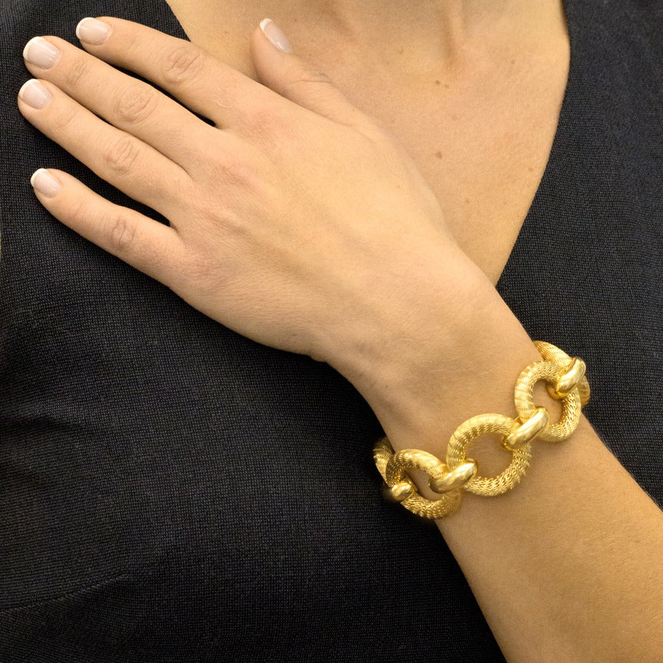 Circa 1960s, 18k, Tiffany & Co., New York.  This sleek sixties bracelet from Tiffany has textured woven rings interspersed with polished gold connecting links. The look is unusual, wearable and stylish. Beautifully made, this is a lovely example of