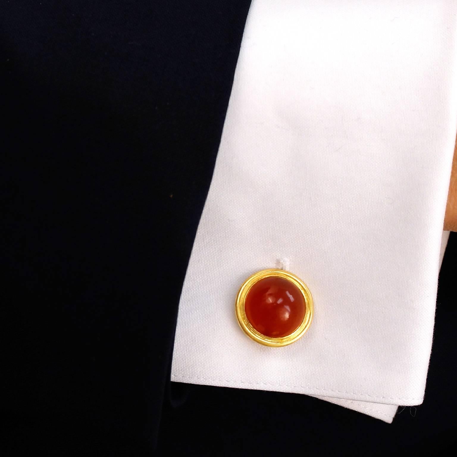 Circa 1950s, 18k.  These sleekly elegant cufflinks are made in polished eighteen-karat yellow gold, impeccably framing vibrant carnelian cabochons.  Well-made and in excellent condition, they will add the perfect dash of color to any suit. 
