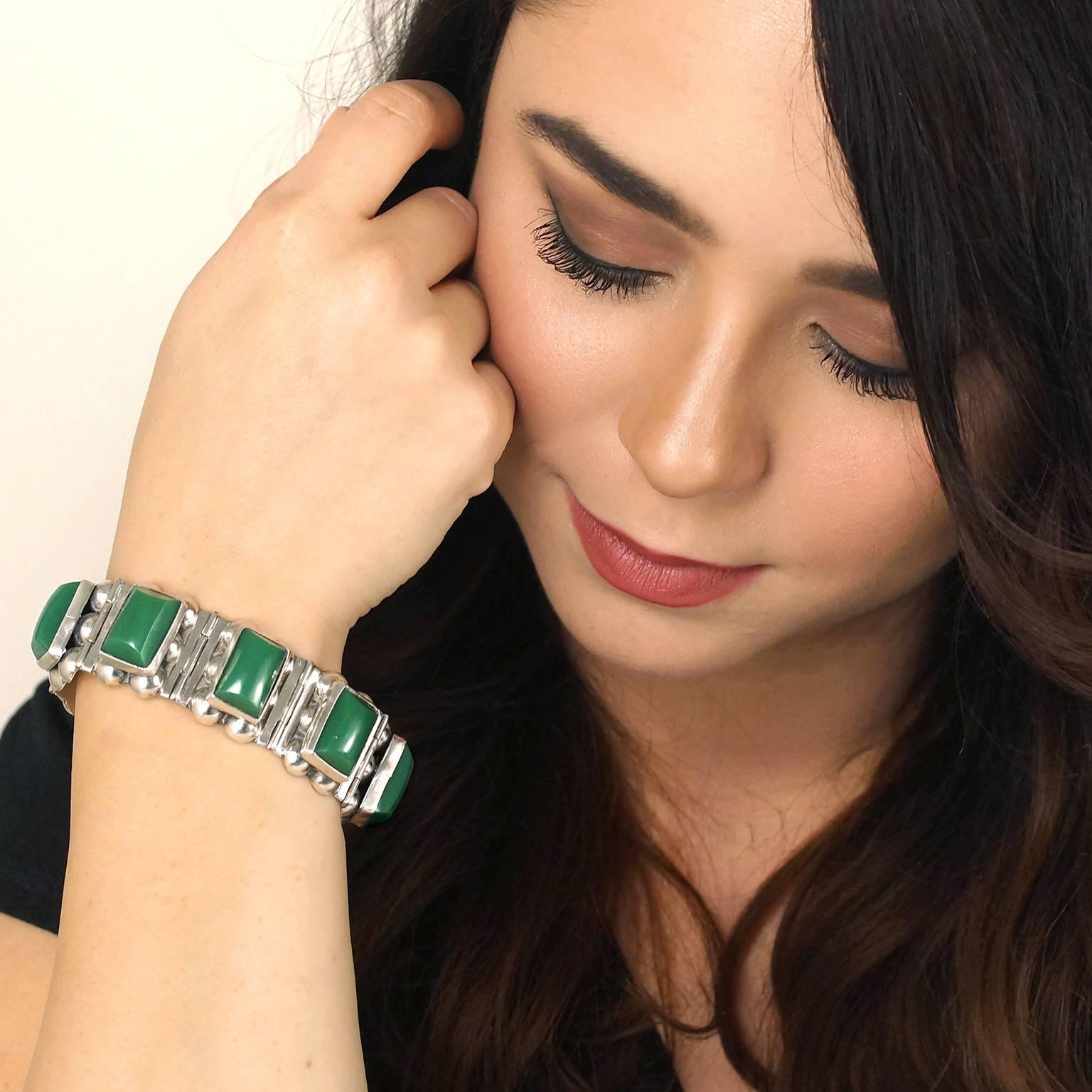 Circa 1960s, Sterling, Mexico.  Bold sixties fashion meets the cool organic feel of Mexican silver-smithing in this vibrant Jensen-esque bracelet. Set with Mexican jade (sometimes green onyx, sometimes glass) this fabulous bracelet brings a