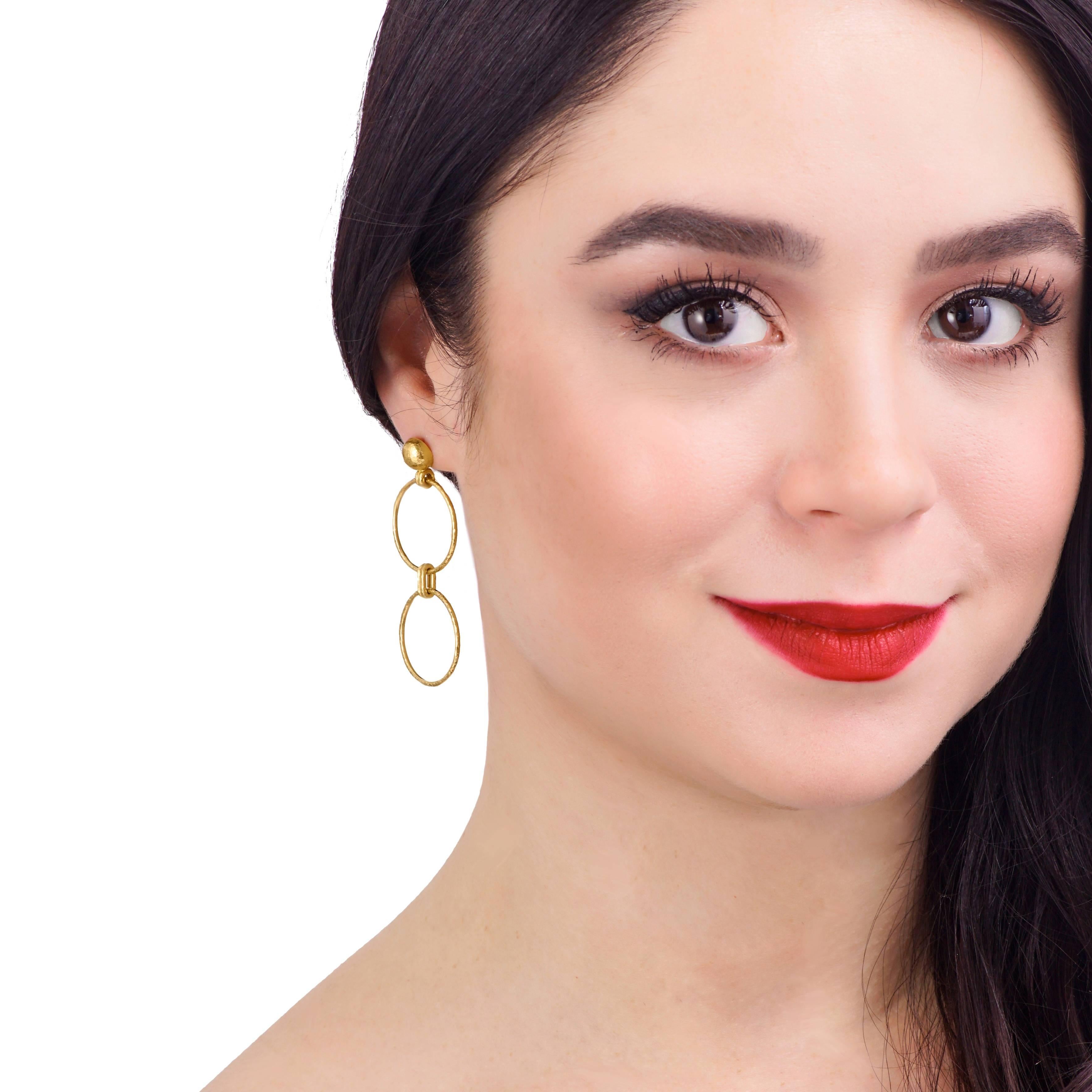 Circa 2000s, 24k, Gurhan, Turkey.  These chic double hoop earrings by Gurhan combine modernist aesthetics with old world élan. Their signature 24-karat yellow gold is finished in a hand-hammered texture, and at 1 1/4 inches long, they are