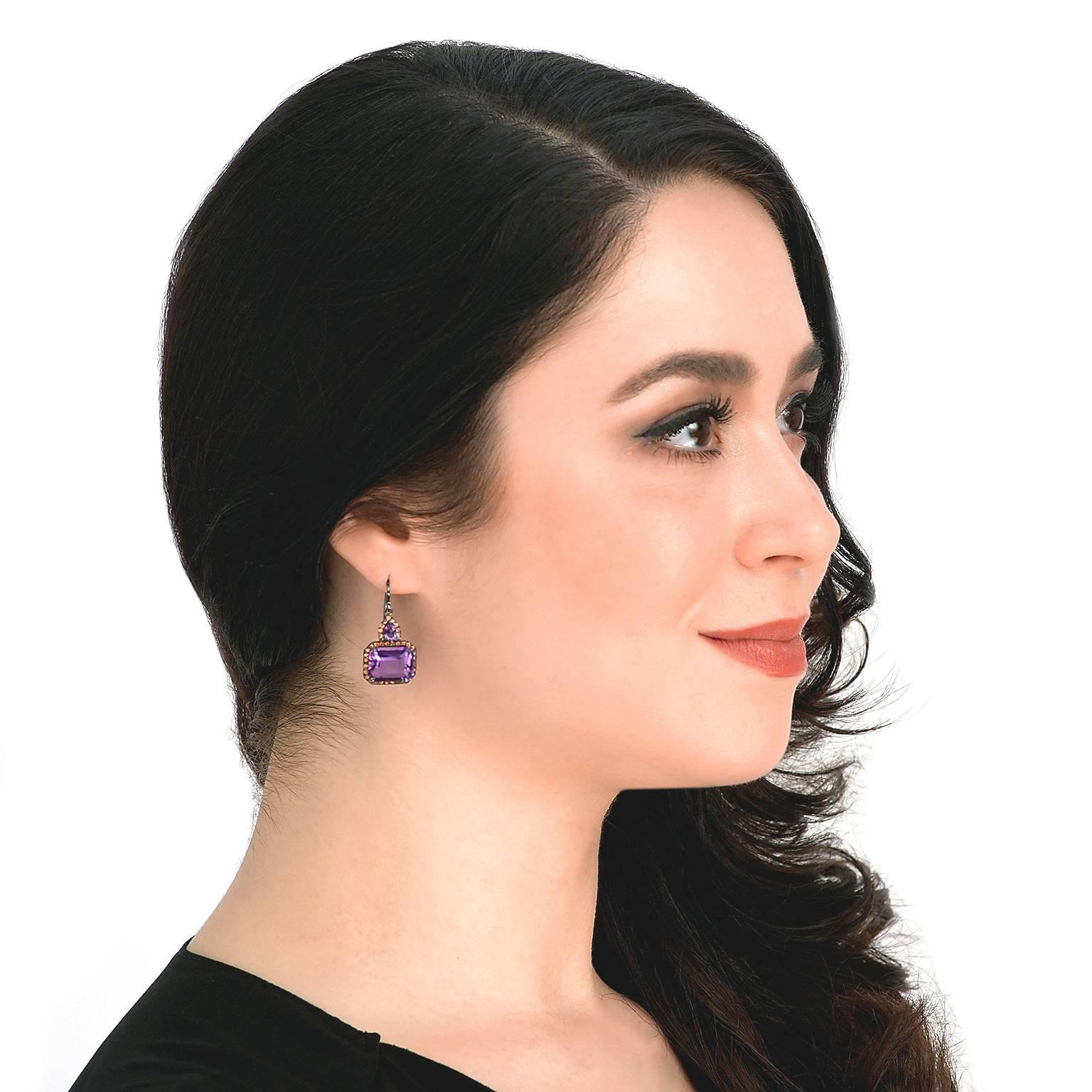 Circa 2000s, 18k, by A & Furst, American.  Blending modern design, classic elegance, and a unique color palette, these earrings have a look that pops. Vibrant amethysts framed by vivid orange sapphires are juxtaposed in blackened eighteen-karat gold