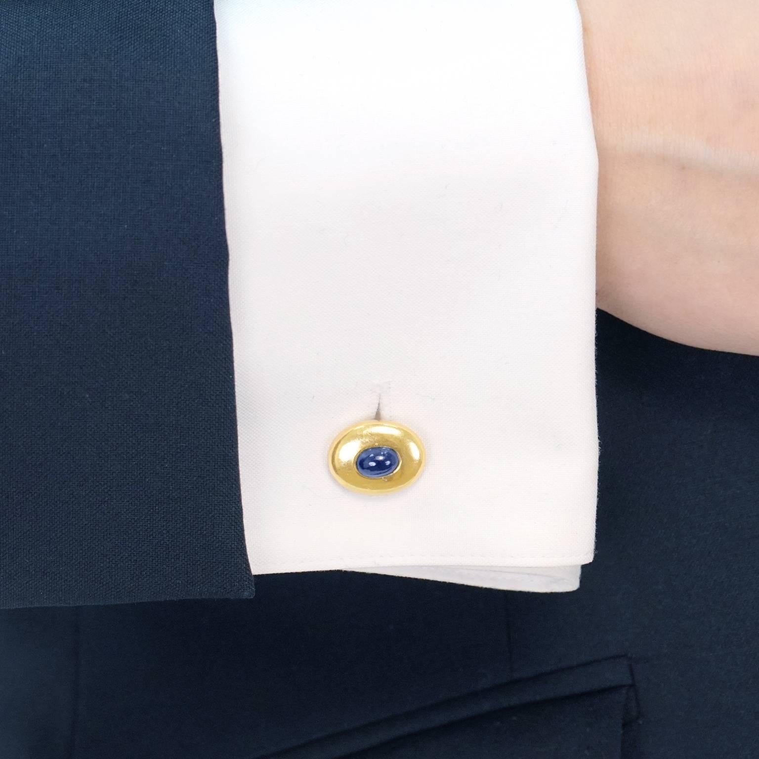 Circa 1950s, 18k, Swiss.   These smart 18k yellow gold cuff links are the perfect, go-to links. Classic and modern in the same sweep of the eye, each is set with a vibrant blue cabochon sapphire. Exquisitely made, they are easy to put in, and hold