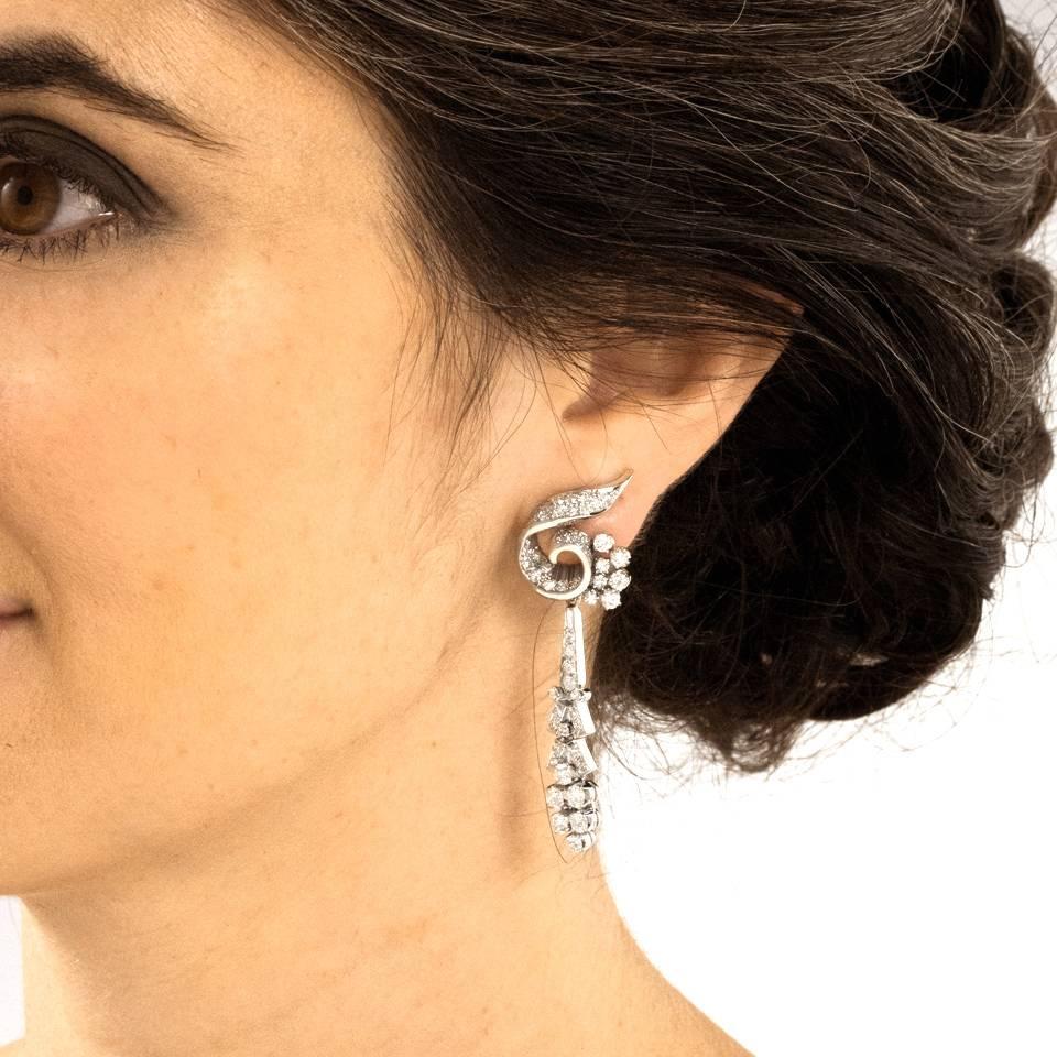 Circa 1950s, Platinum, American.  Entirely about sparkling diamonds and chic good looks, these fifties chandelier earrings have it all - 5.0 carats of brilliant white stones, fabulous length, and flirty movement. Meticulously fabricated in platinum,