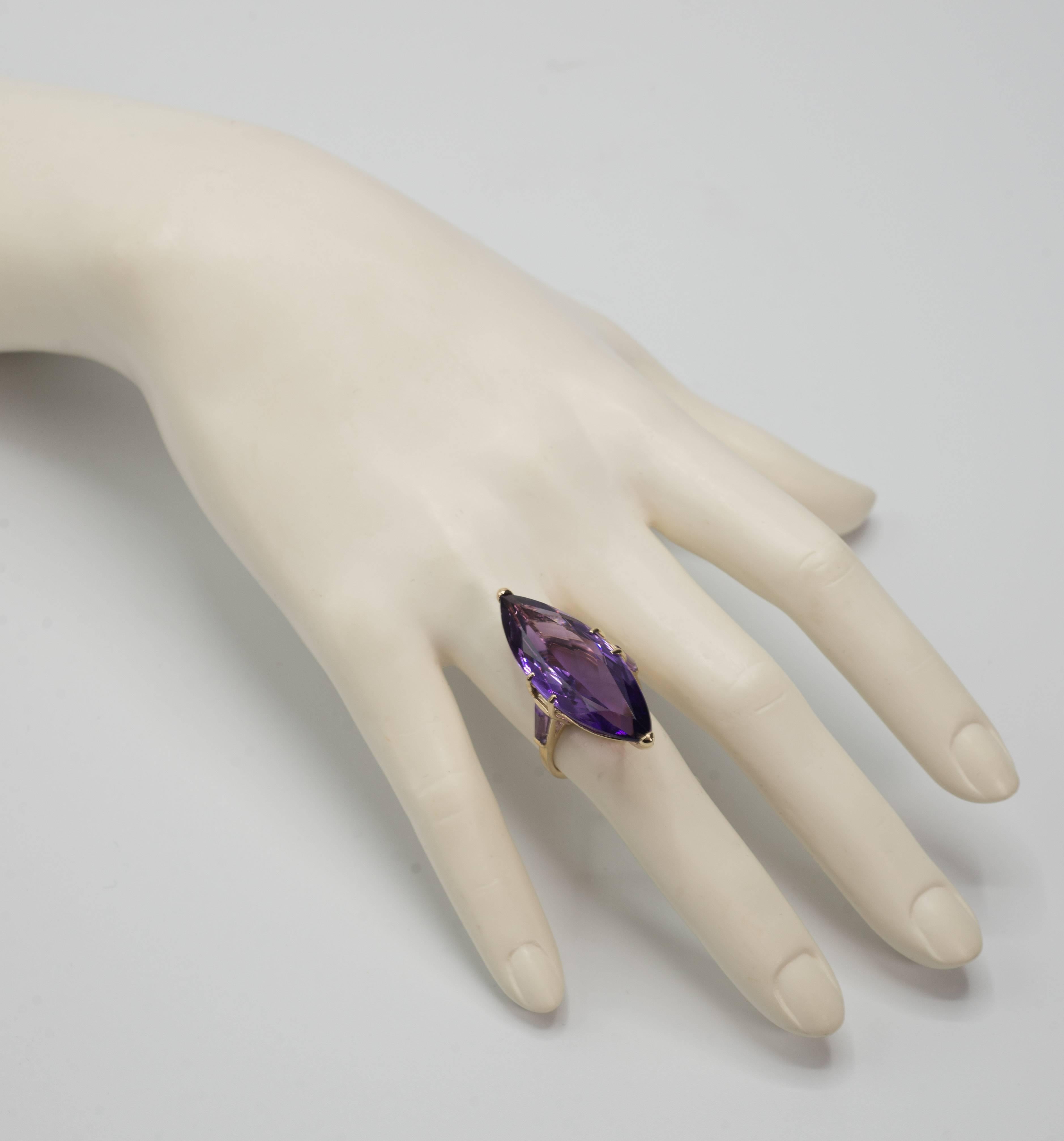 Large  purple Amethyst marquise cut  matching side taper baguettes yellow 14karat gold ring. The Amethyst weighs approximately 25 carats set in 14karat yellow gold. The ring is 1.5 inches long by .75 inches wide. Sizing is free. Special order takes