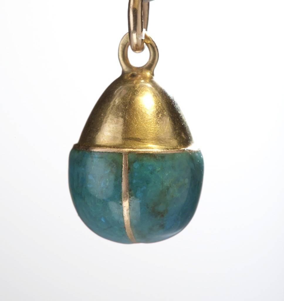 A rare Russian gold miniature egg pendant designed as a turquoise enameled acorn with gold cap and gold suspension ring. 

St. Petersburg, circa 1880, stamped on the inner ring. 

3/4 in. (1.9 cm) long, including outer ring, egg alone measures 5/8