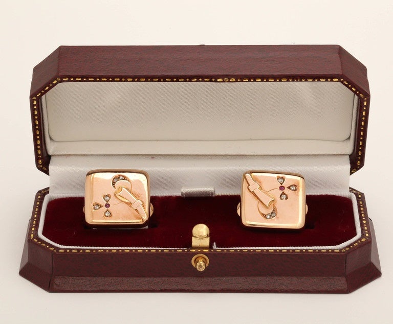 A pair of rare Romanov-era cufflinks, period of Tsar Alexander III, designed as rose gold squares with rounded edges, each inset with a rose diamond and ruby clover, symbol of the Holy Trinity in the Russian tradition enhanced with rose gold ribbon