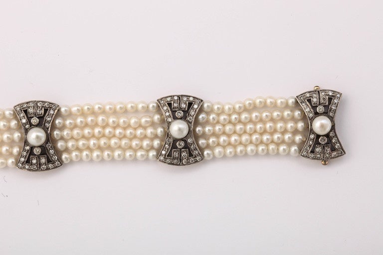 Beautiful five-strand pearl bracelet recalling the Belle Epoque, the lustrous pearls enhanced with five openwork 18k gold spacers in the shape of bows each set with 30 diamonds and centering a white half-pearl, mounted in silver and gold.

Pearls