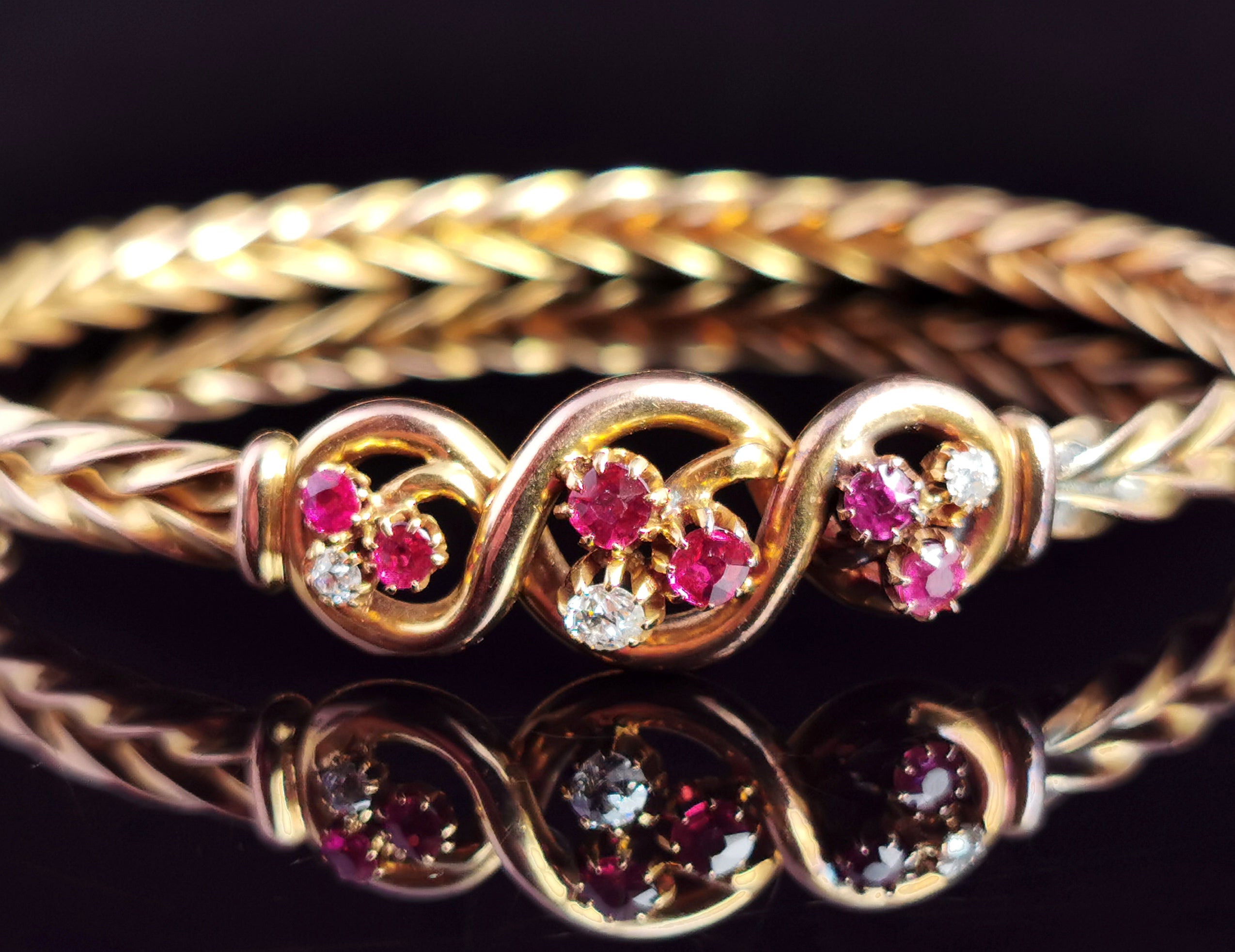 A gorgeous antique, Victorian era Ruby and Diamond bangle.

This piece has got everything going for it and oozes Victorian charm, this was made for a lady of style, one who wanted to stand out.

The 15ct yellow gold bangle has a decorative wheat